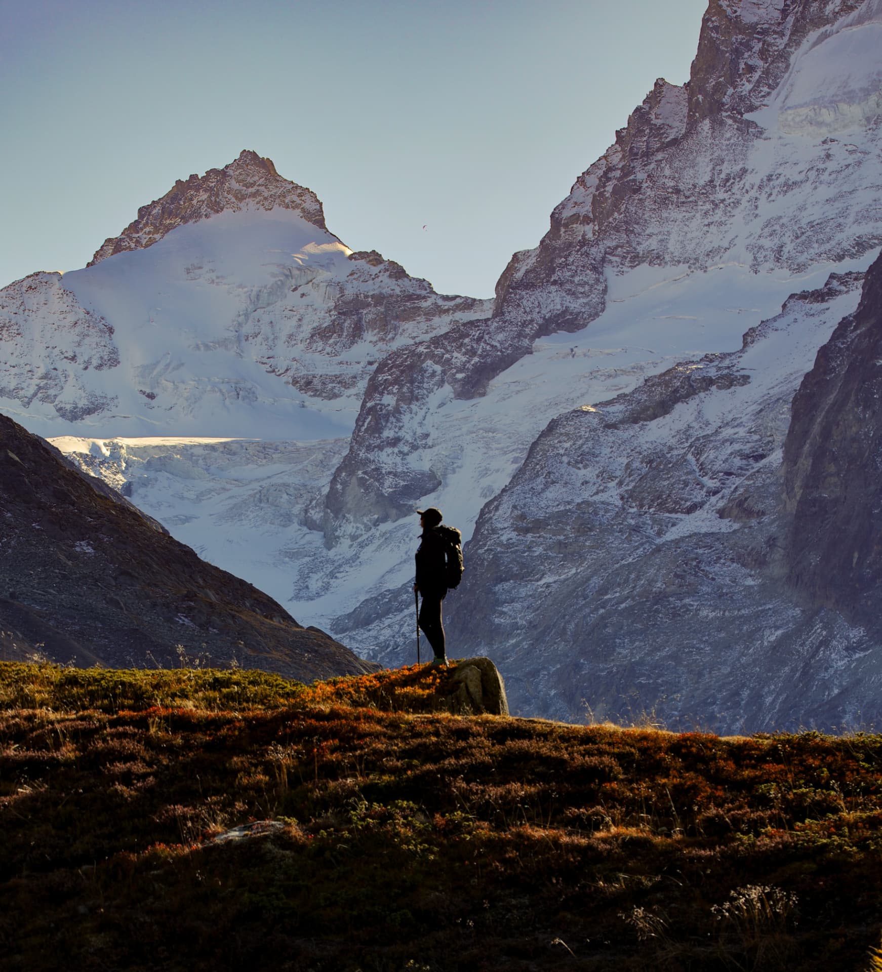 Wanderin vor verschneiten Wänden im Sonnenaufgang