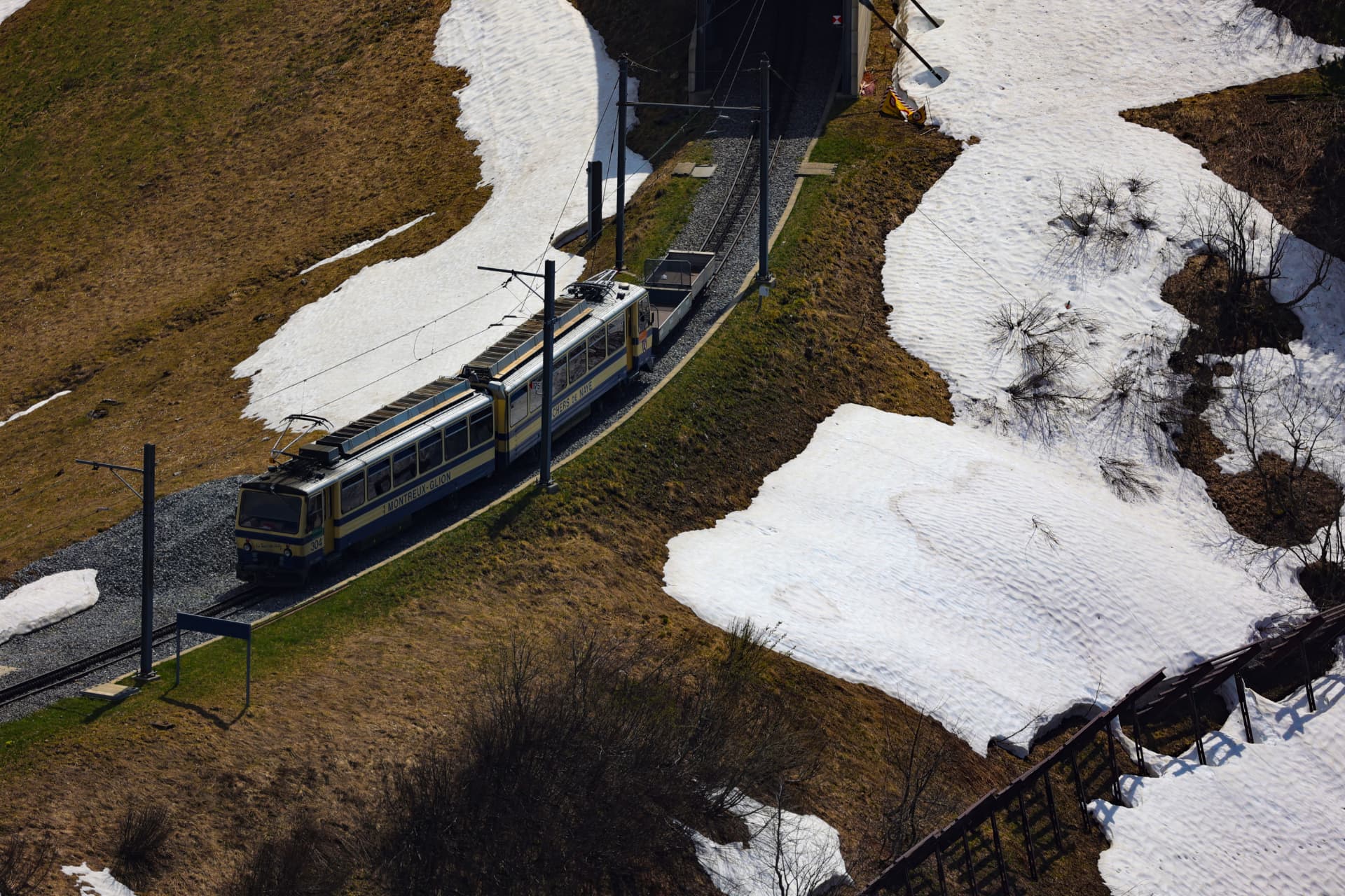 Wagen der Zahnradbahn Montreux–Glion auf dem Gleis zwischen Schneeflecken