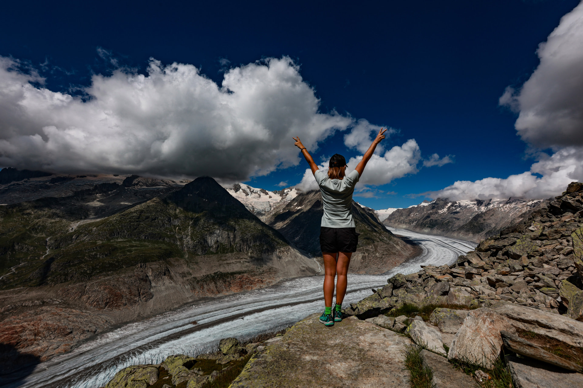 Person mit erhobenen Armen über dem Aletschgletscher