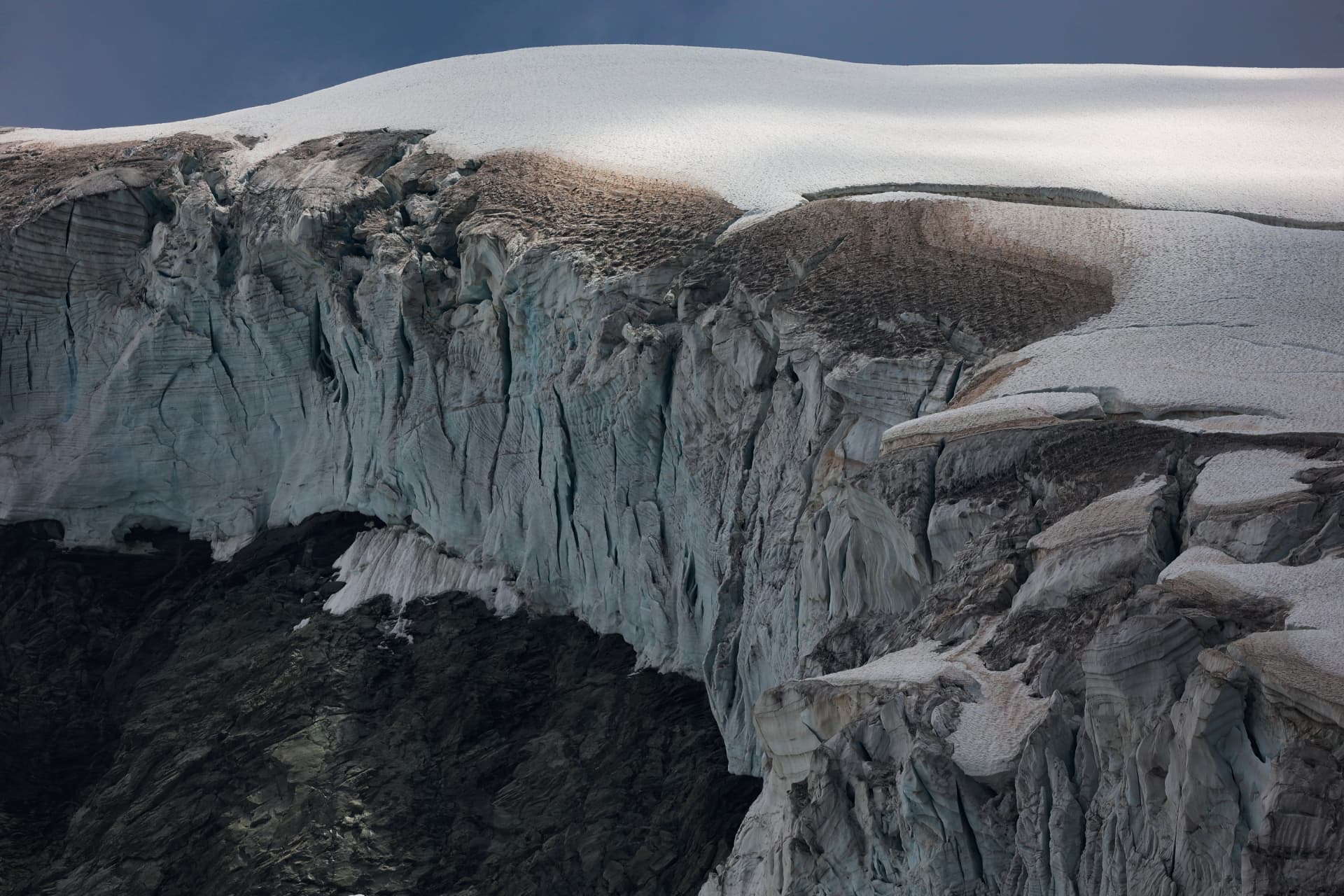 Gletscherabbruch — gebrochenes Eisgewölbe über dunklem Fels