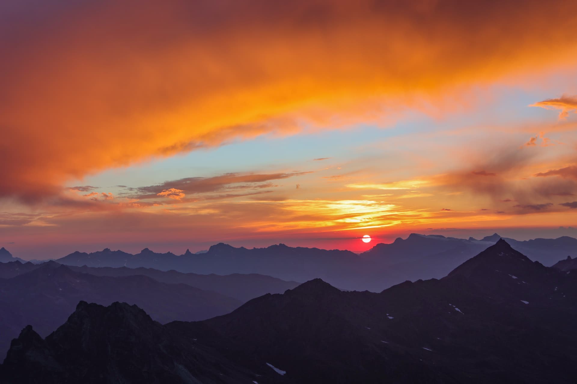 Sonnenscheibe über dem Alpenhorizont