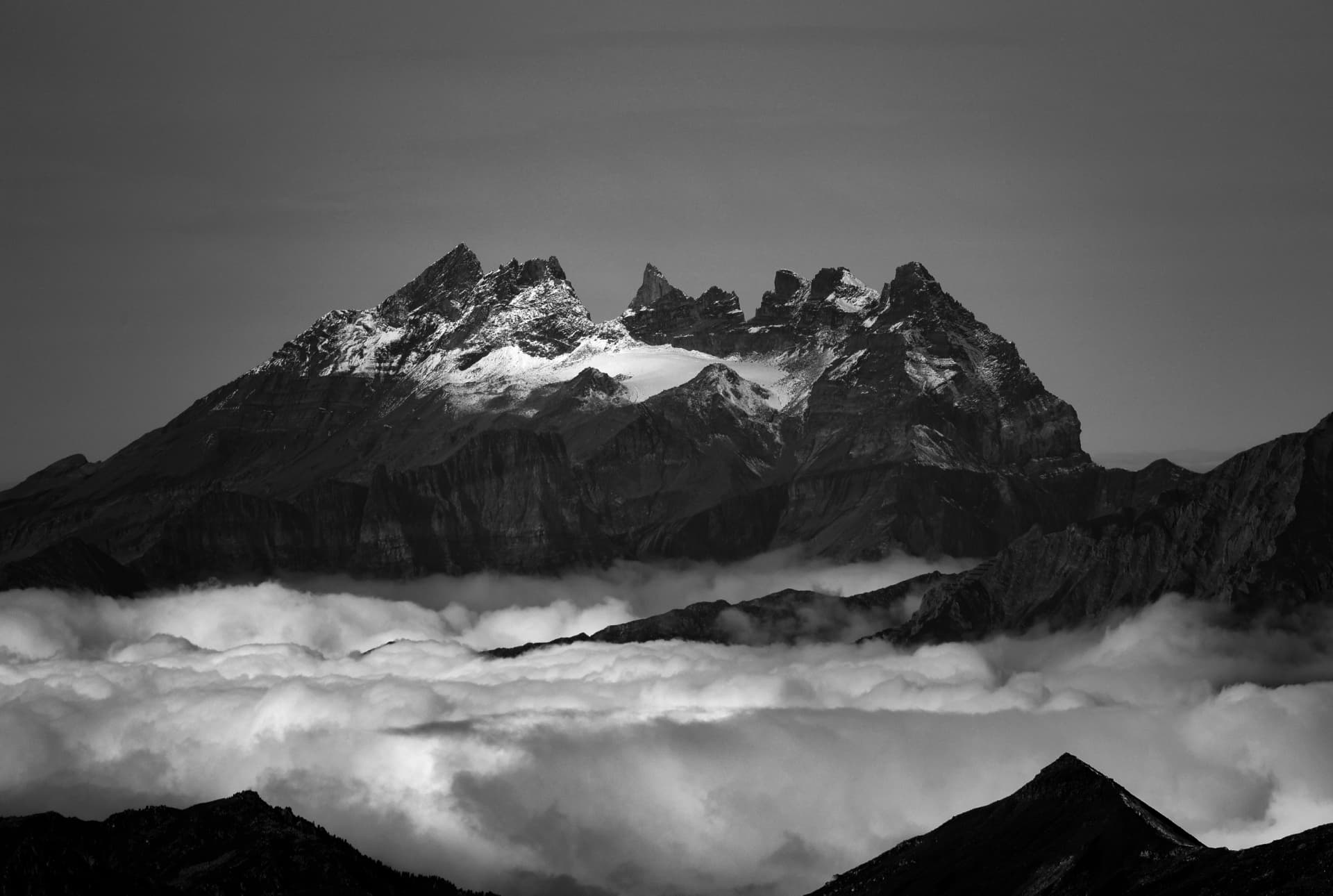 Gezacktes Bergmassiv über einem Wolkenmeer in Schwarz-Weiß