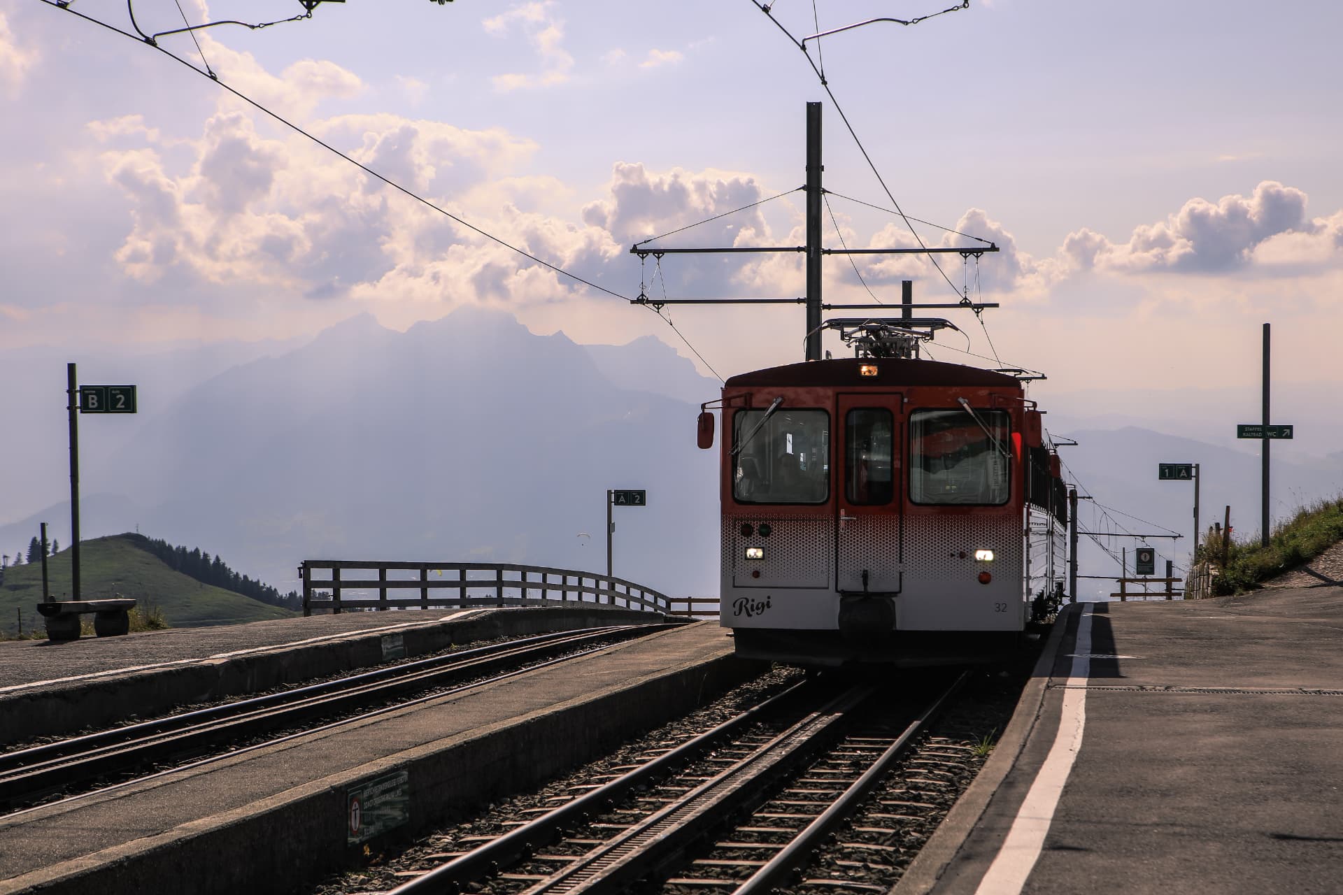 Roter Wagen der Rigi-Zahnradbahn auf dem Perron mit Bergpanorama