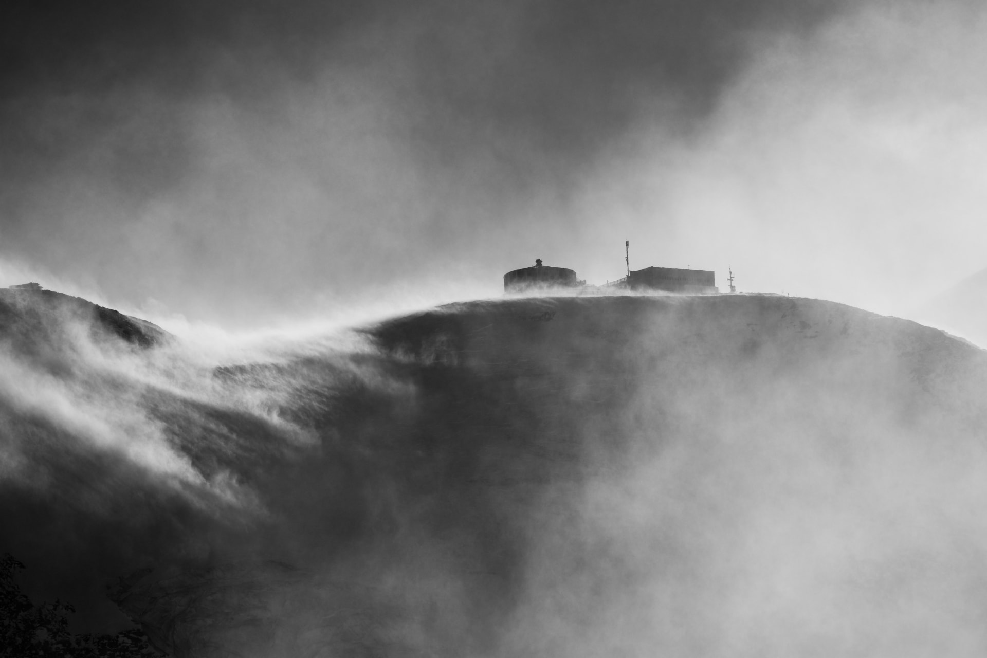 Gipfelstation am Rücken im Schneetreiben, schwarzweiß
