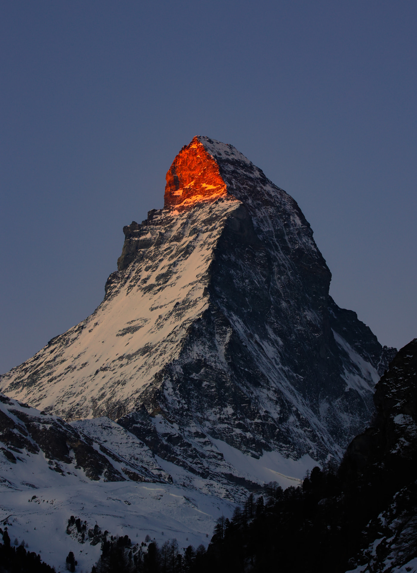 Matterhorn-Gipfel im roten Alpenglühen bei Morgendämmerung, die Wand im tiefblauen Schatten
