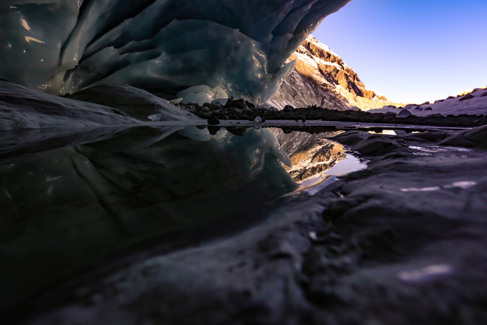 Sonnenaufgang spiegelt sich im Wasser am Gletschertor