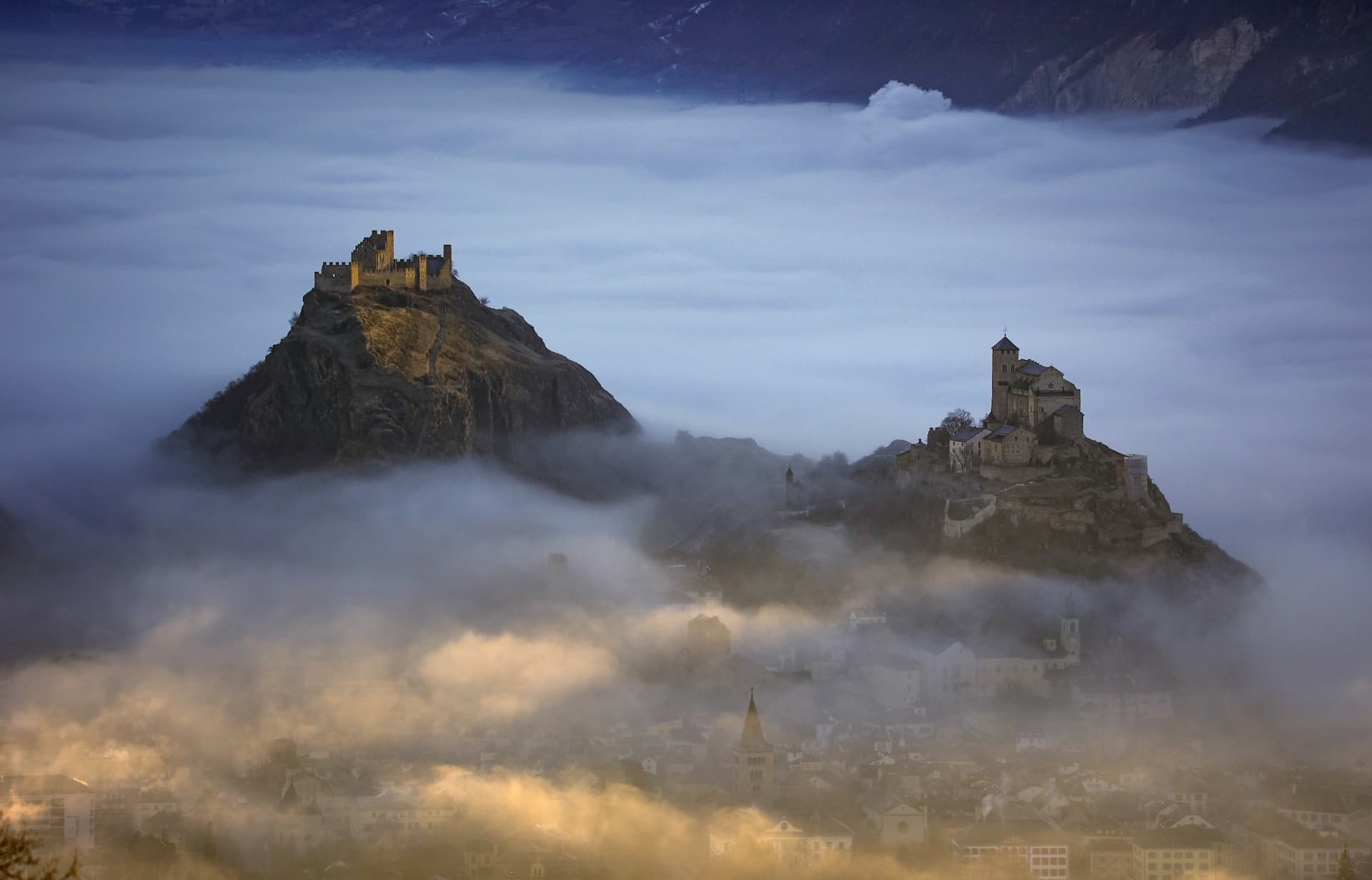 Die Hügel Valeria und Tourbillon über dem Nebel bei Sion