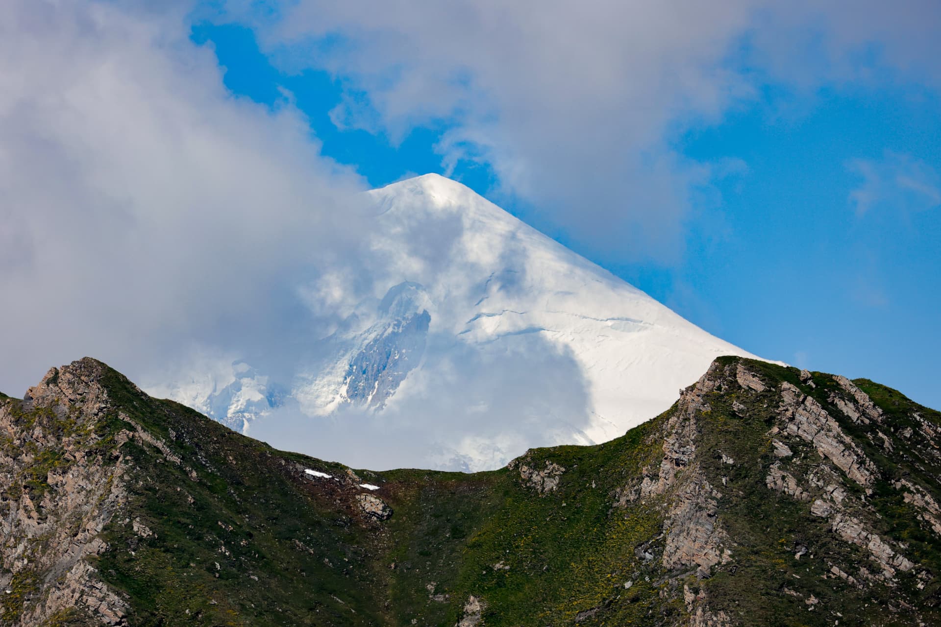 Verschneiter Alpengipfel zwischen Wolken