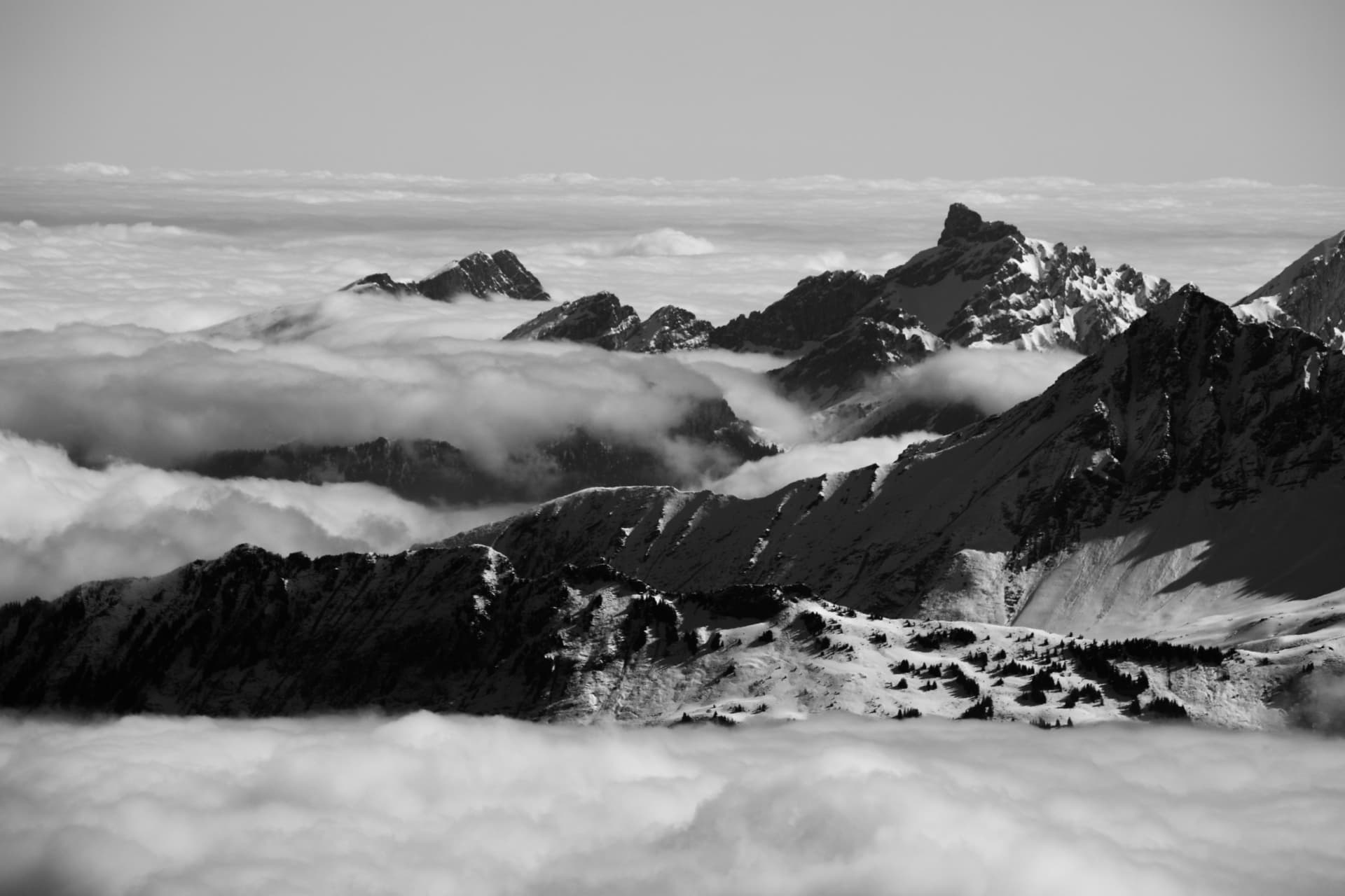 Schwarz-weiße Panorama der Grate über dem Nebelmeer