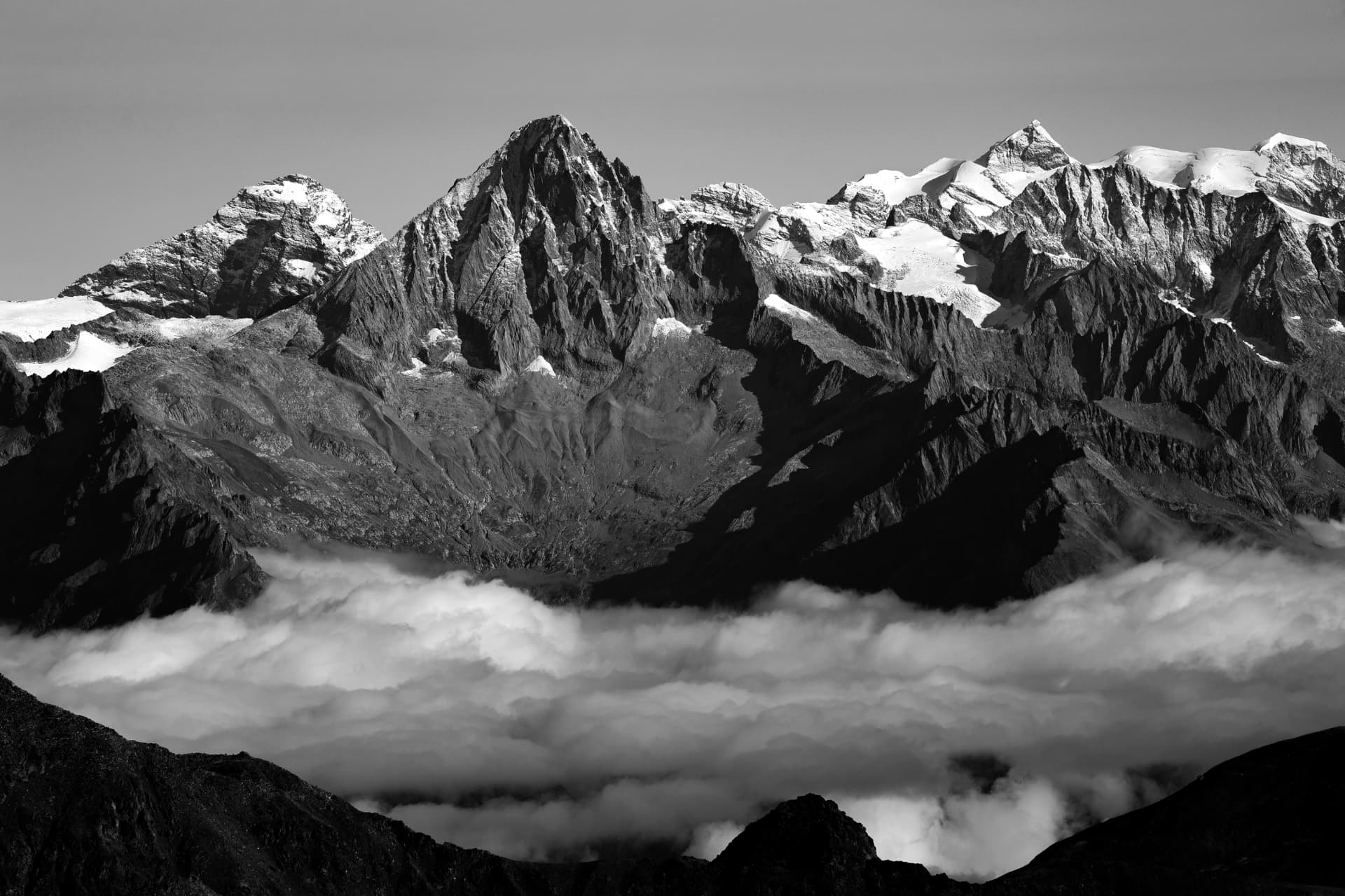 Schwarz-Weiß-Panorama gezackter Gipfel über Wolken