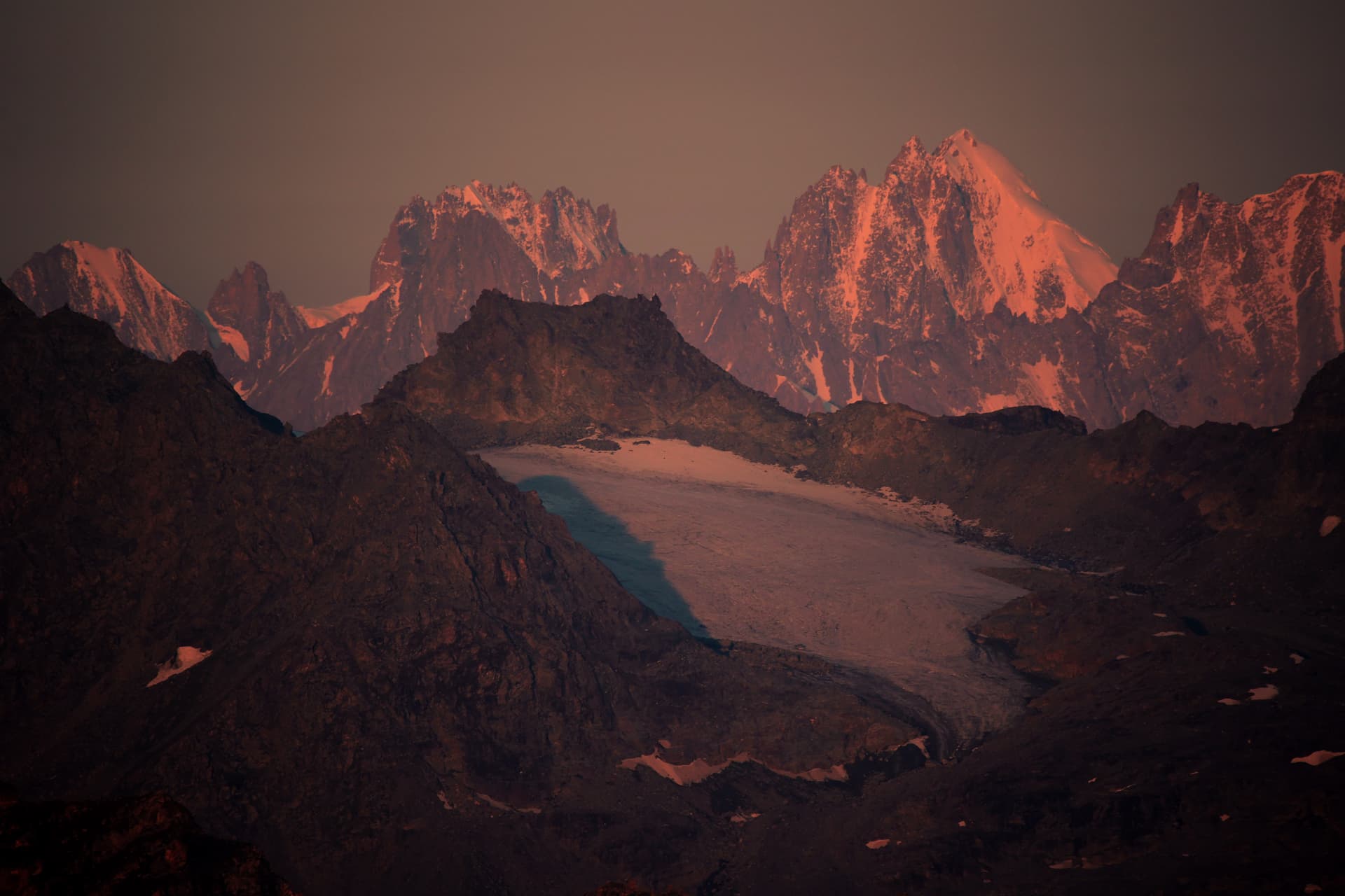 Die Aiguilles de Chamonix im Alpenglühen über einem Gletscher