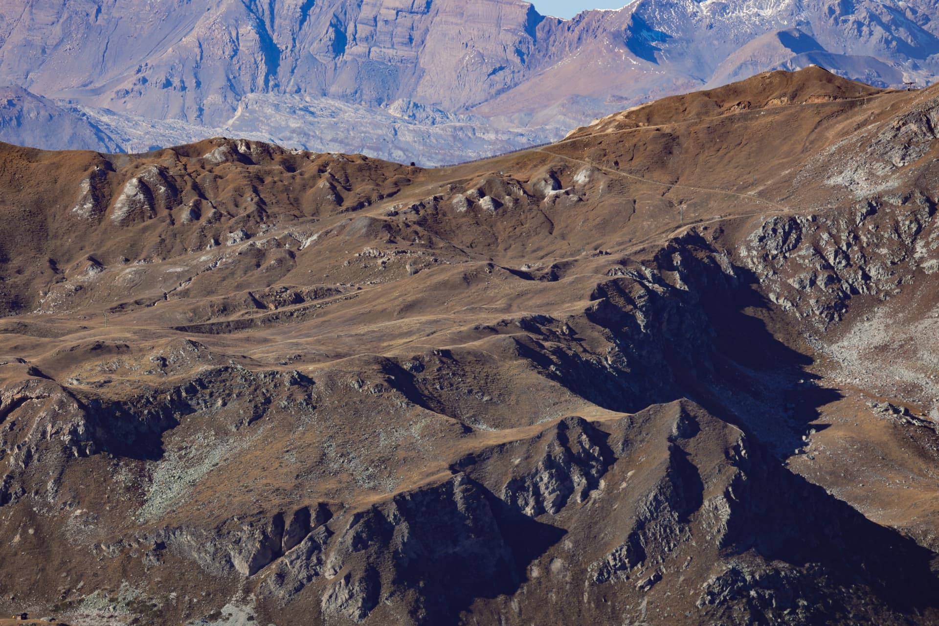 Goldbraune Grate und felsige Mulden in der Alpenlandschaft