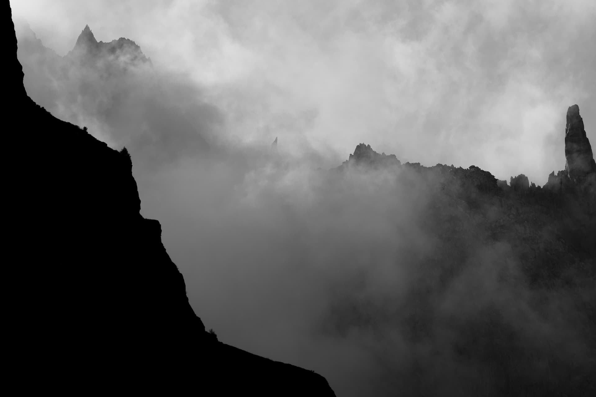 Scharfe Felstürme im Nebel über dem Val Ferret, in Schwarzweiss