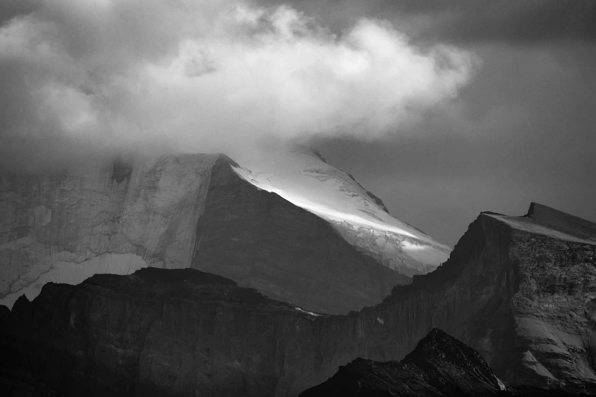Schwarzweisses Lichtband auf dem Gletscher unter der wolkenverhangenen Weisshorn-Wand