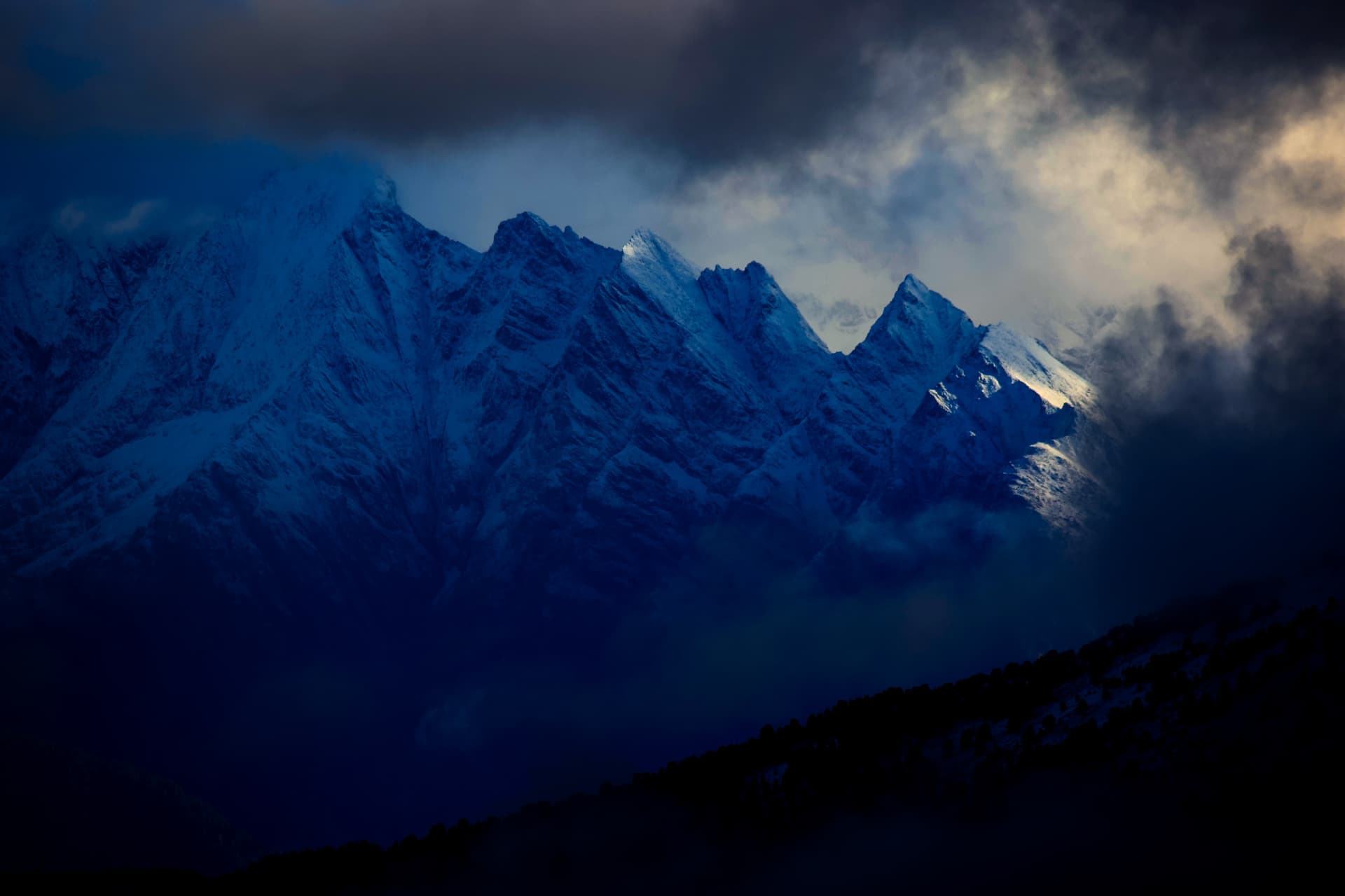Verschneite Bergwand im blauen Winterlicht über Thyon