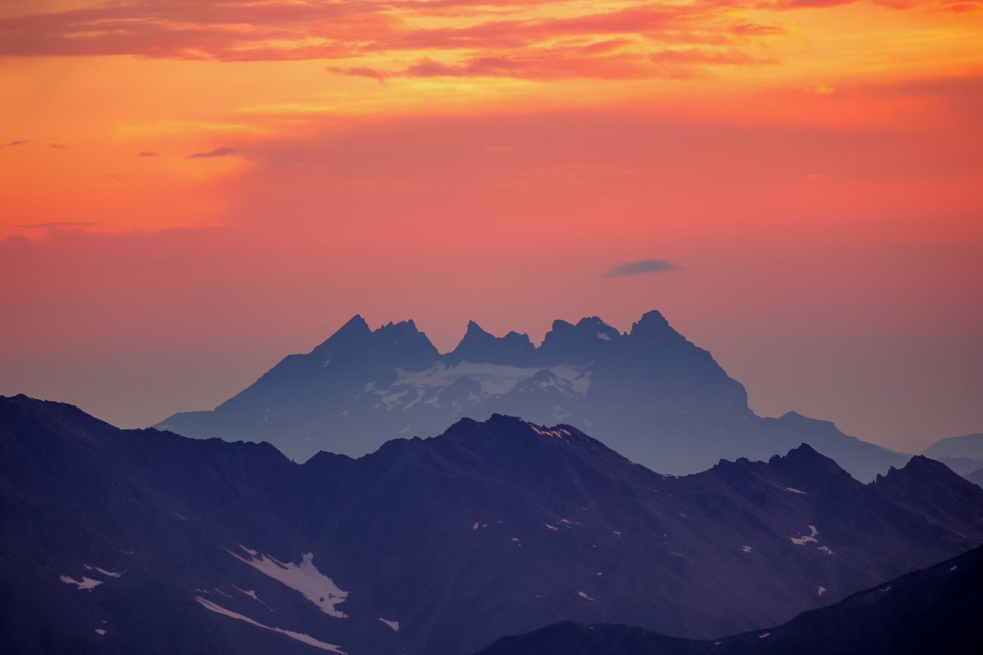 Silhouette der Dents du Midi im orangen Himmel