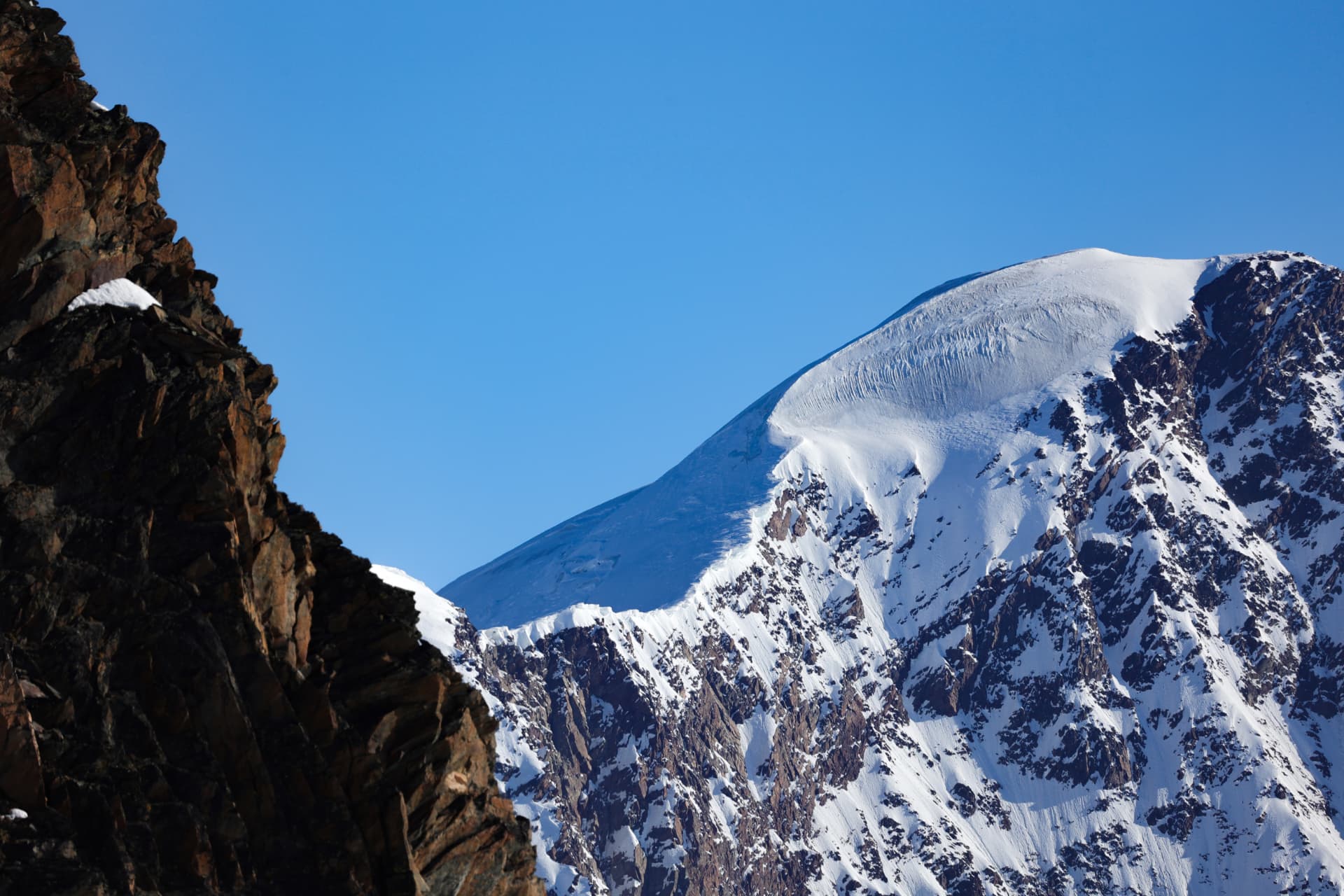 Verschneite Gipfelkuppe über dem Gletscher im Saastal