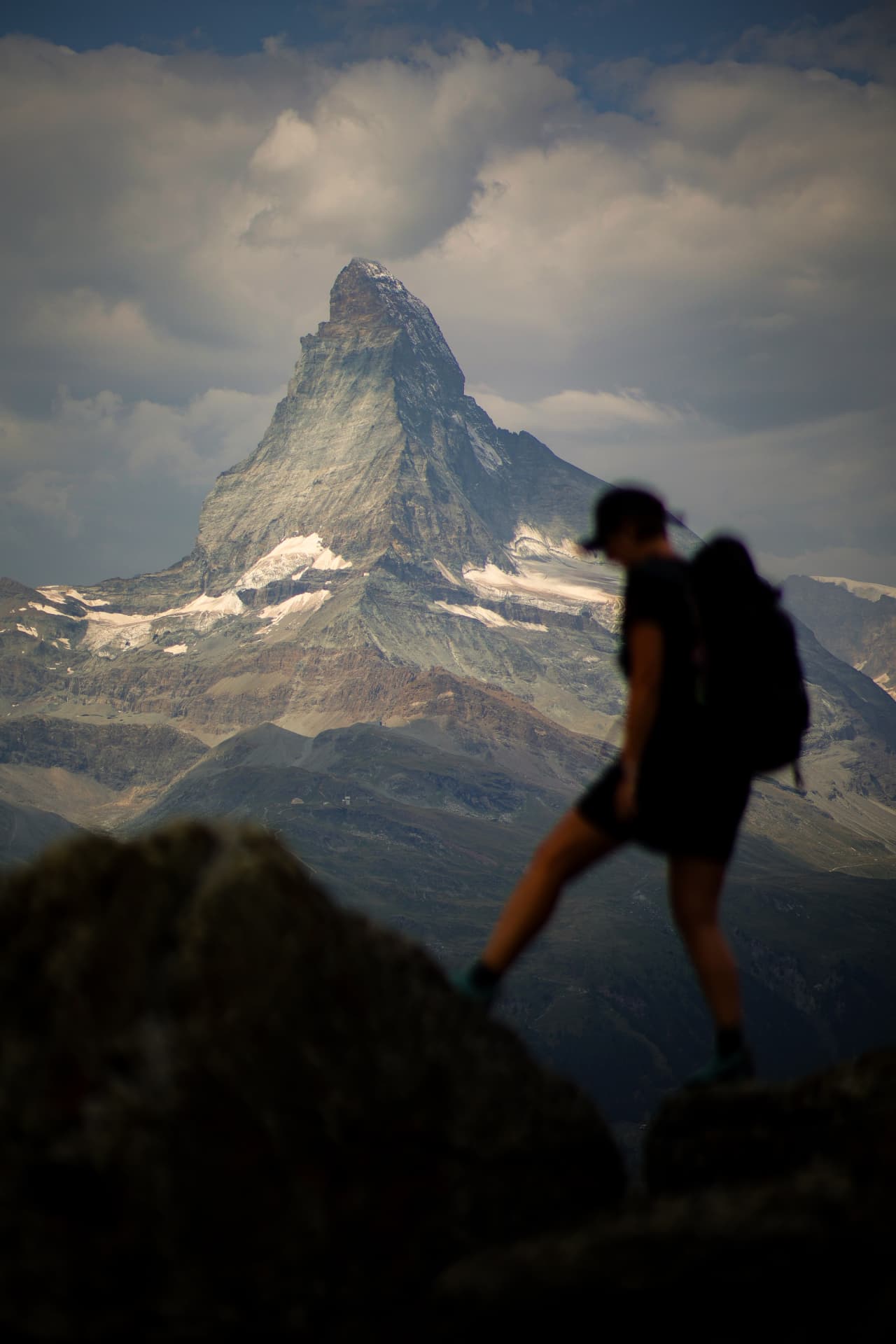 Hiker on a rock in front of the Matterhorn