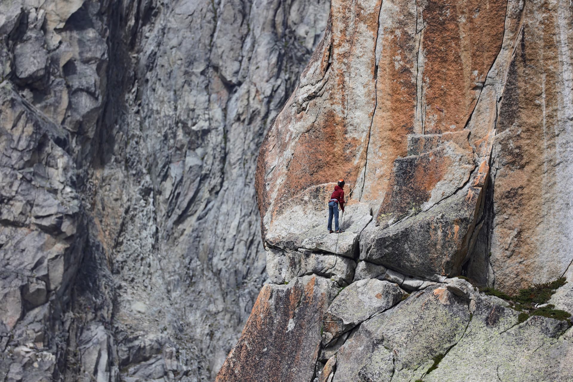 Kletterer an roter Granitwand an der Furka