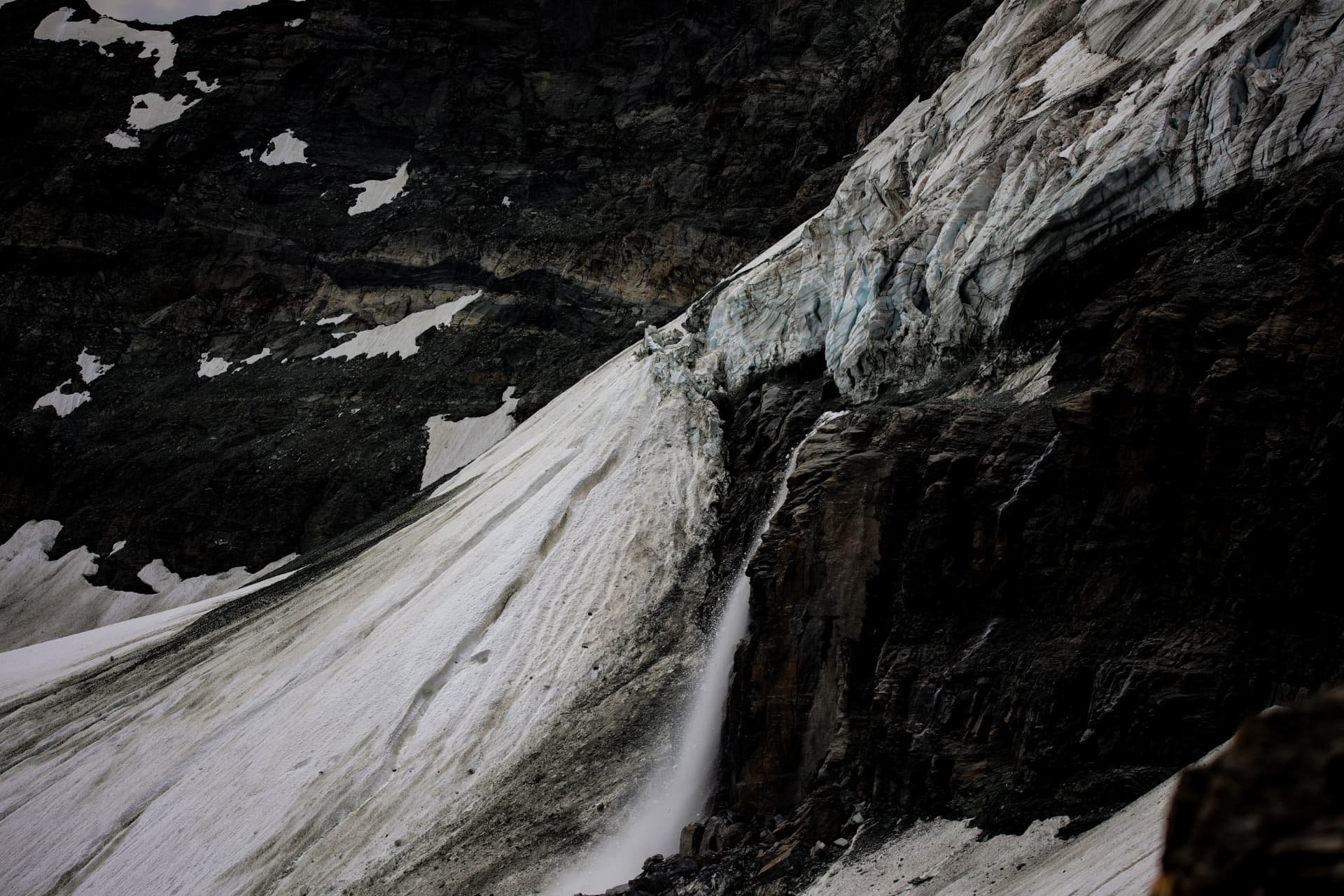 Gletscherrand mit Séracs und Wasserfall über dunkler Felswand