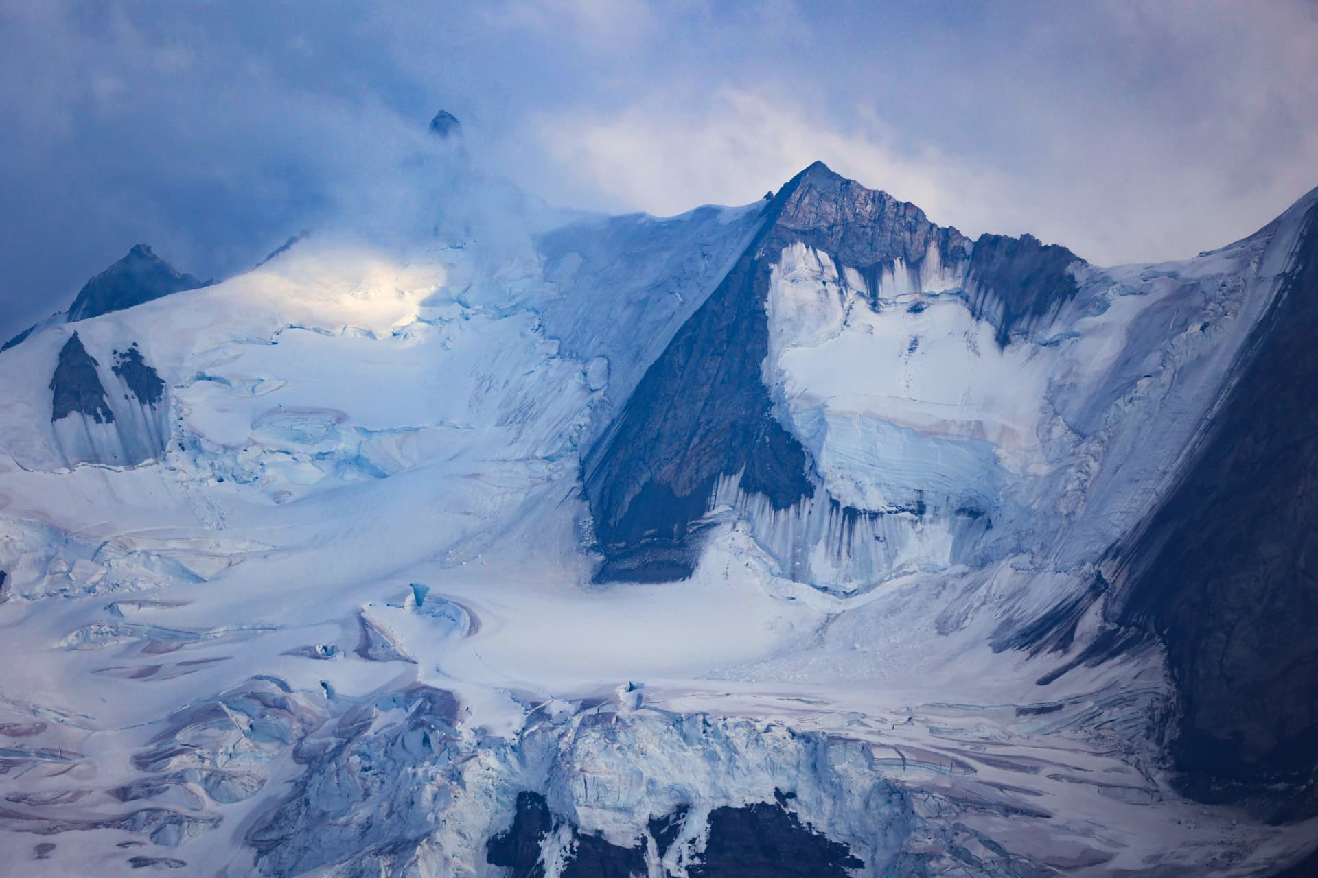 Blaues Abendlicht auf einem zerklüfteten Gletscher unter dem Grat