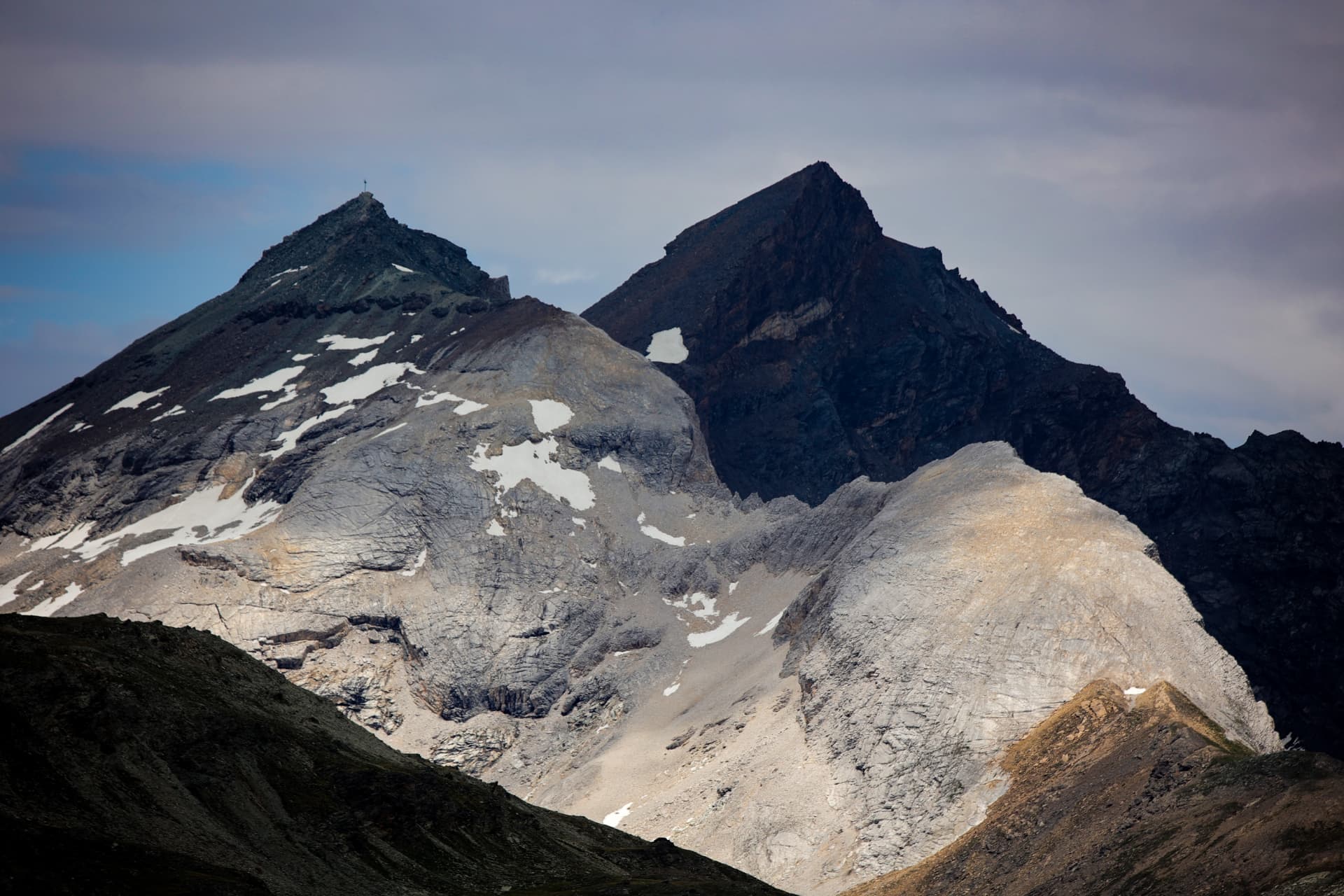Felsgipfel mit Gipfelkreuz über Zermatt in hartem Licht