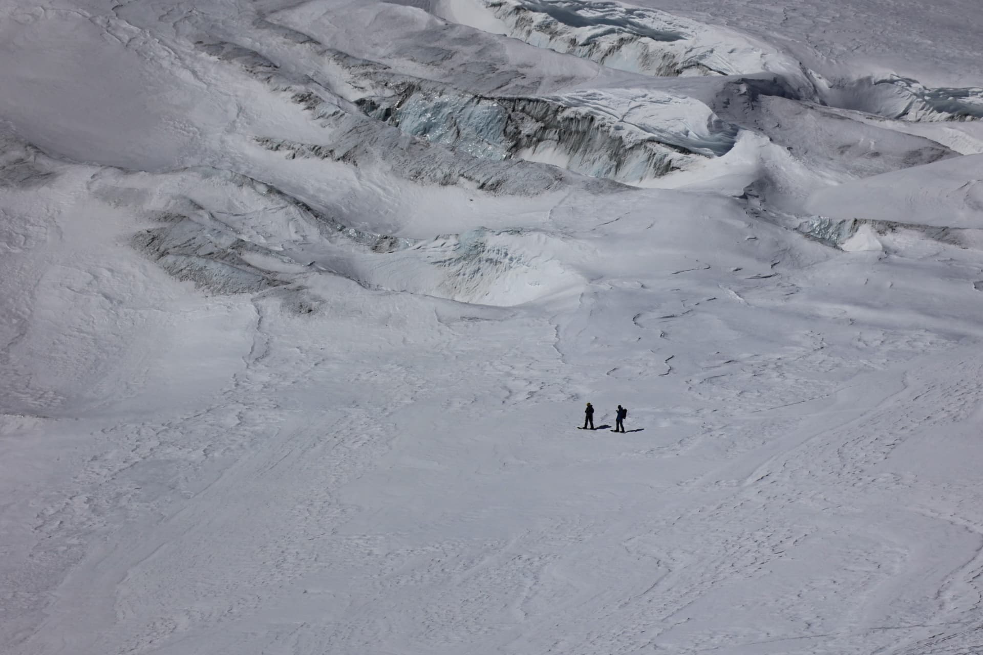 Zwei Skitourengänger auf dem Gletscher unter zerklüftetem Eisbruch