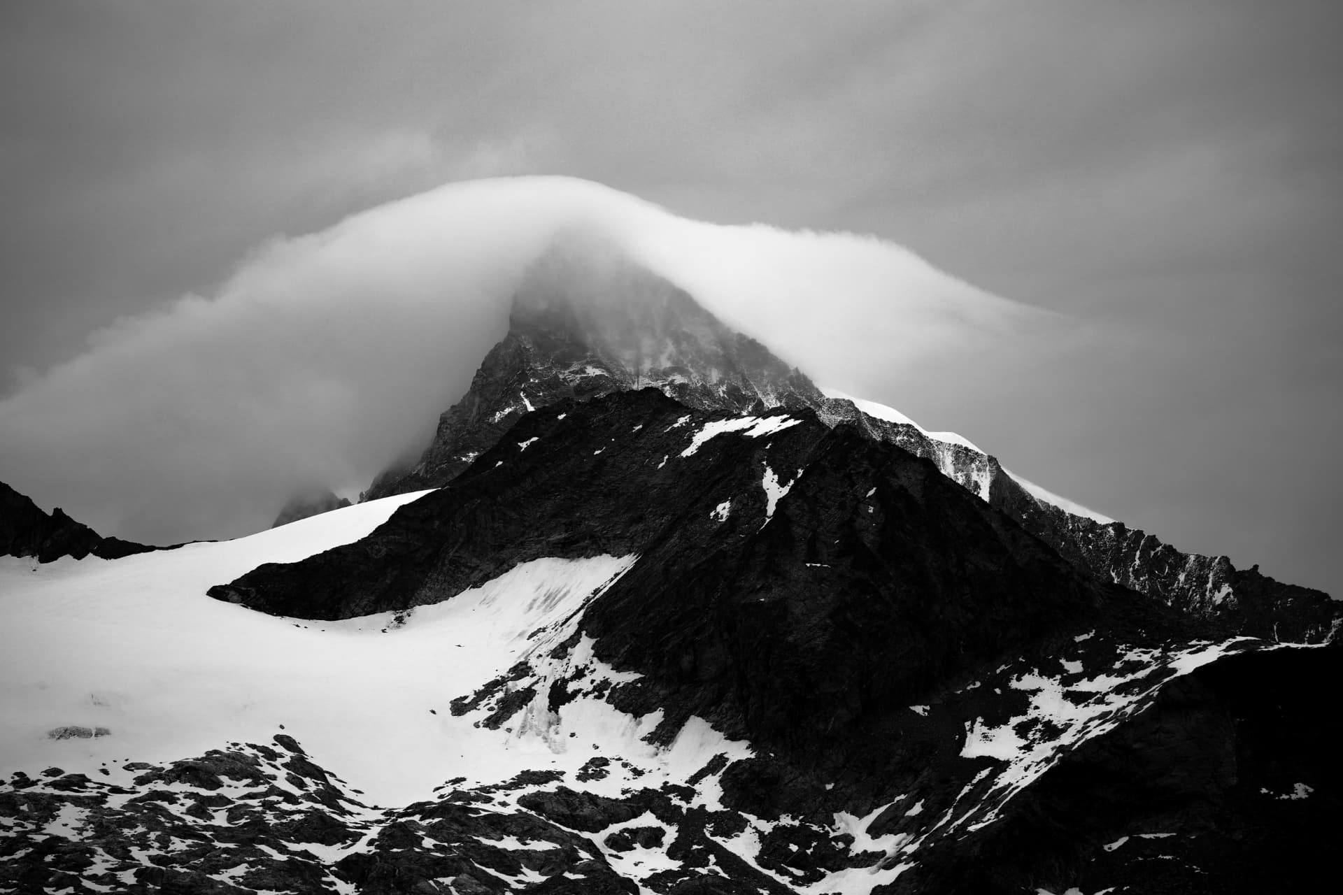 Wolkenkappe über einem Gipfel, schwarzweiss