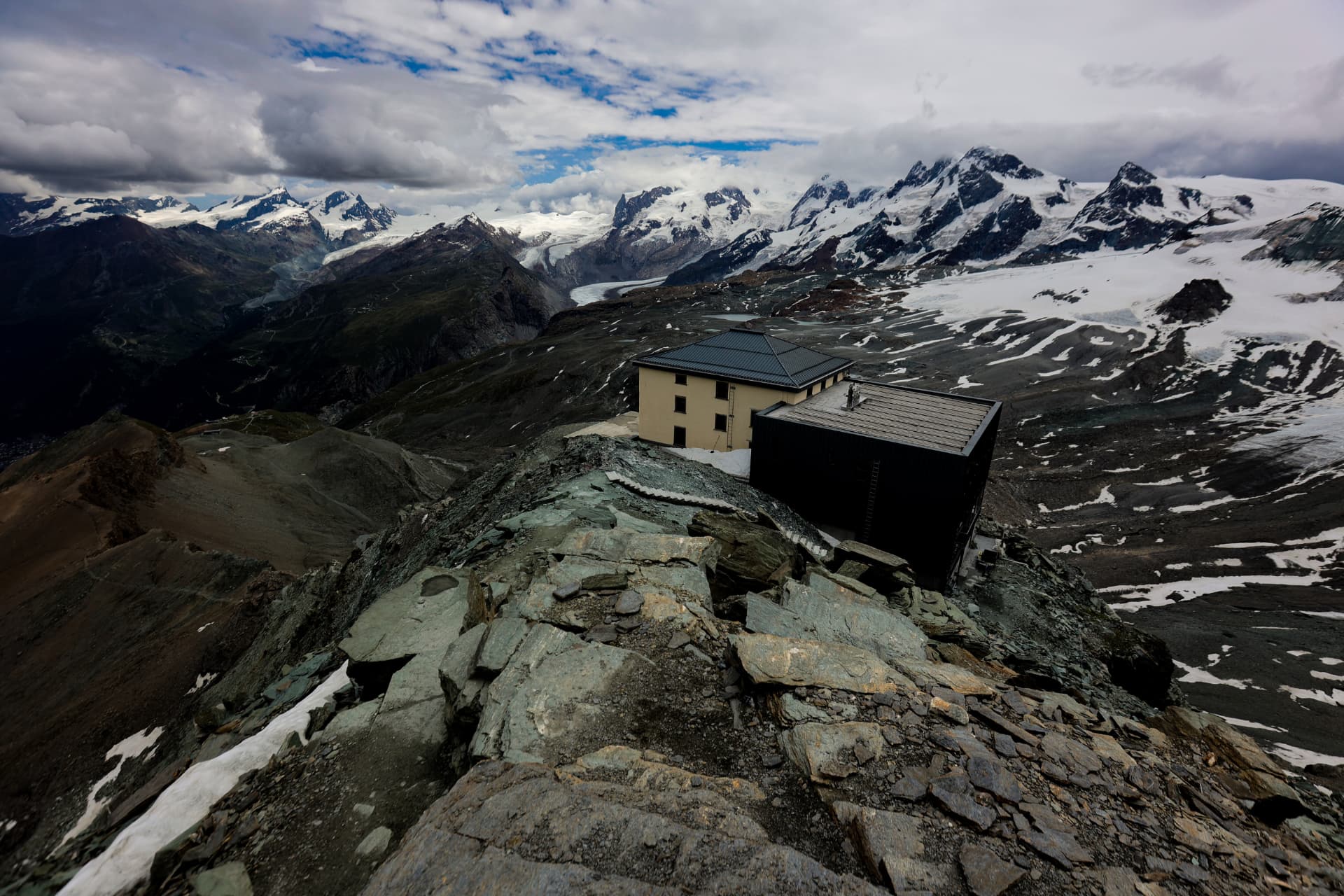 Berghütte auf einem Felsrücken mit Panorama über Gletscher und Monte Rosa