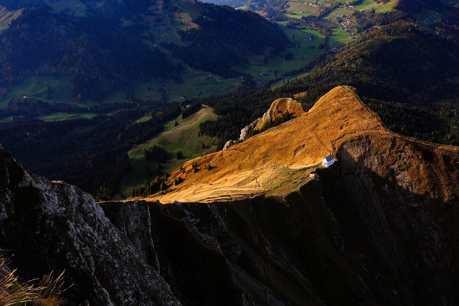 Grate des Pilatus-Massivs im goldenen Abendlicht mit einer kleinen Kapelle