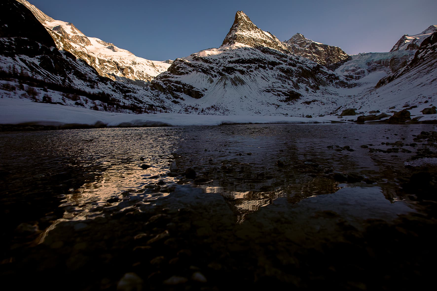 Wintermorgen über dem gefrorenen Vorfeld mit gespiegeltem Gipfel