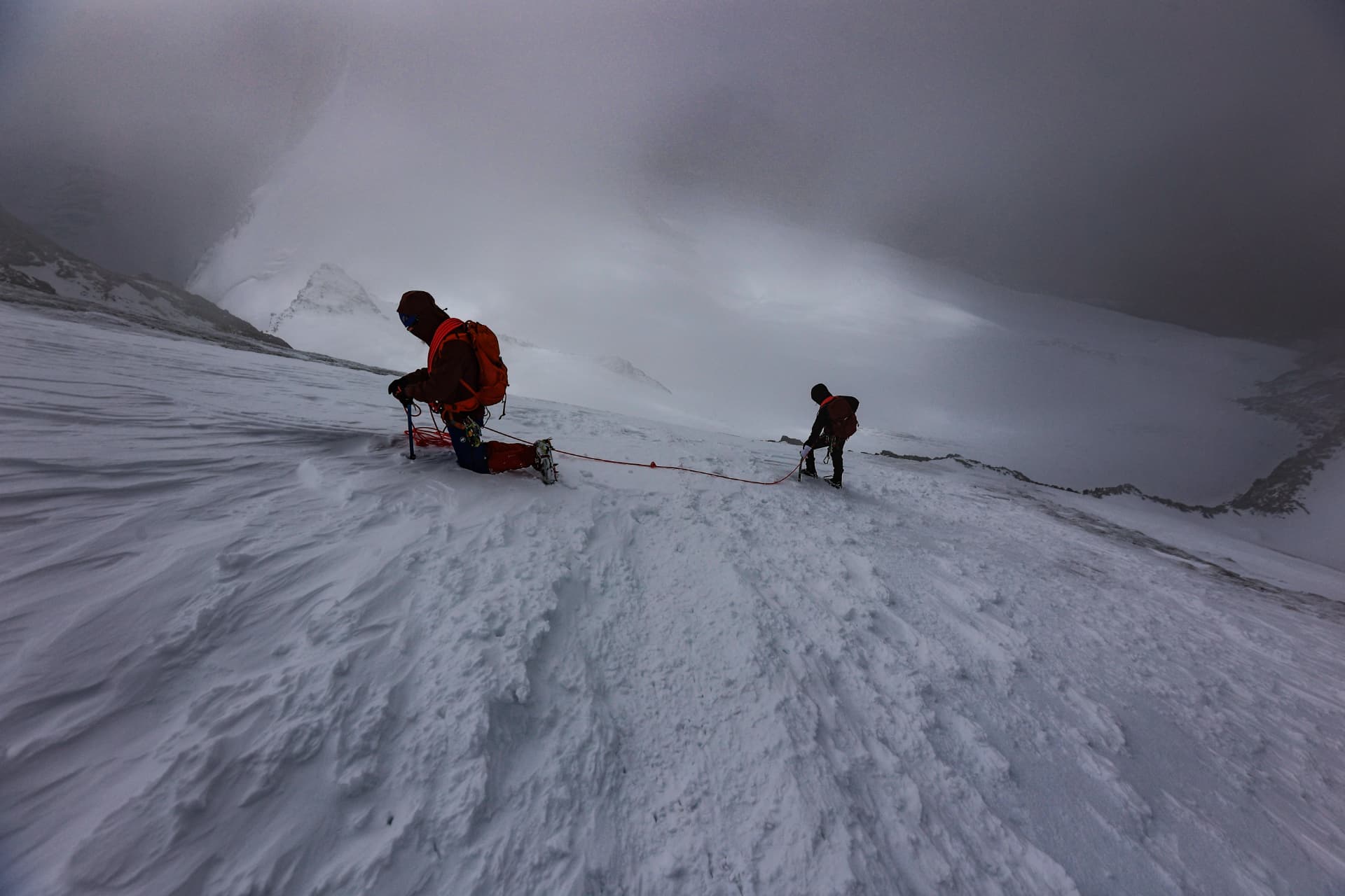 Bergsteiger im Whiteout auf dem Gletscher, Wind und Nebel