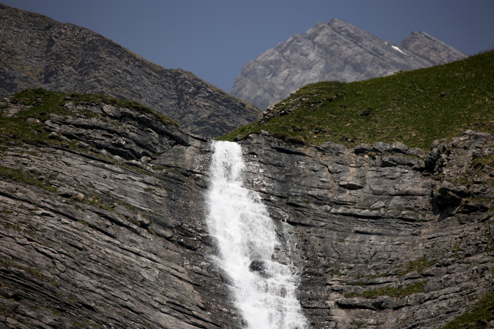 Wasserfall, der auf dem Weg unterhalb der Cabane Rambert über Felsplatten stürzt