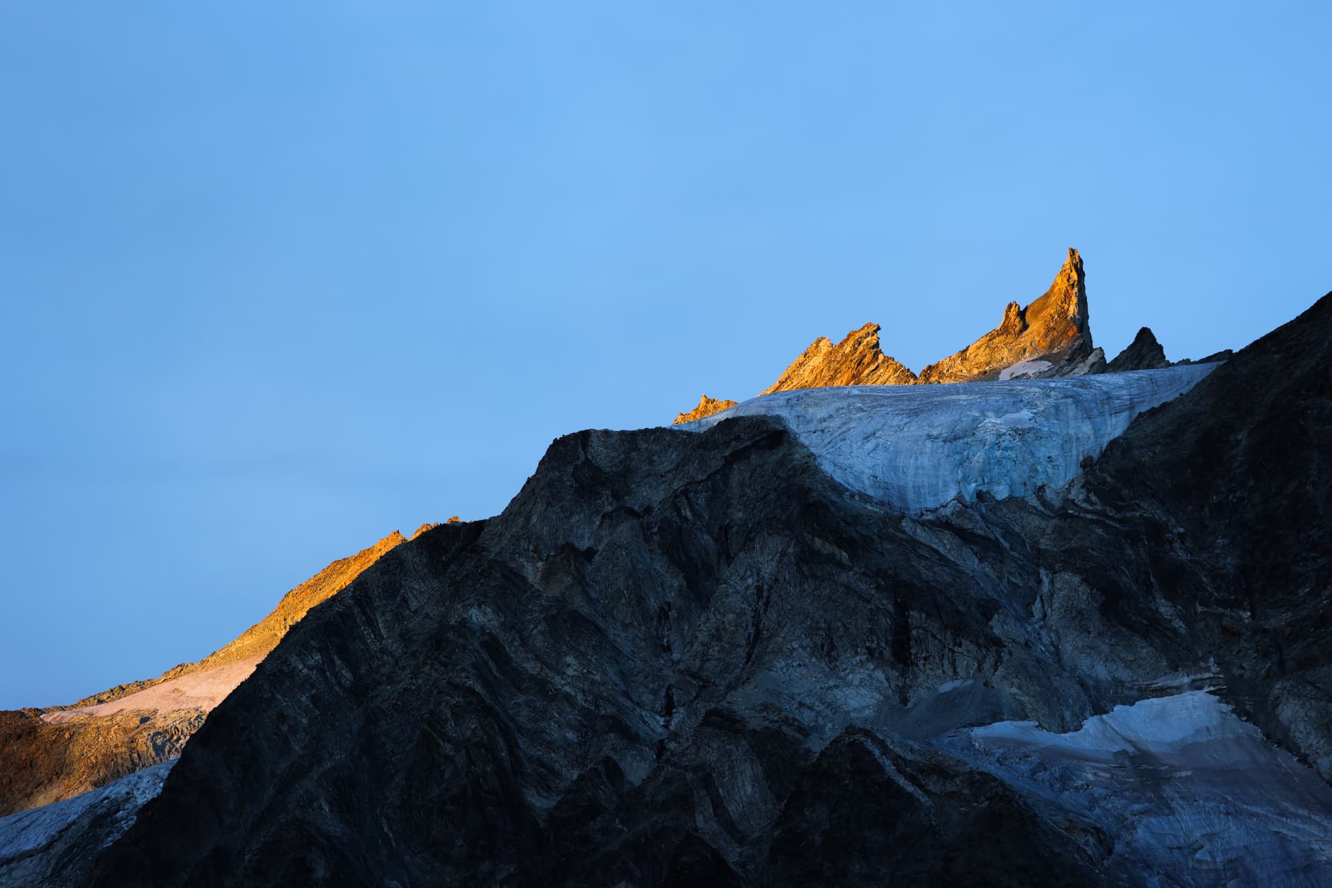 Erstes Licht auf Felsnadeln über dem Gletscher
