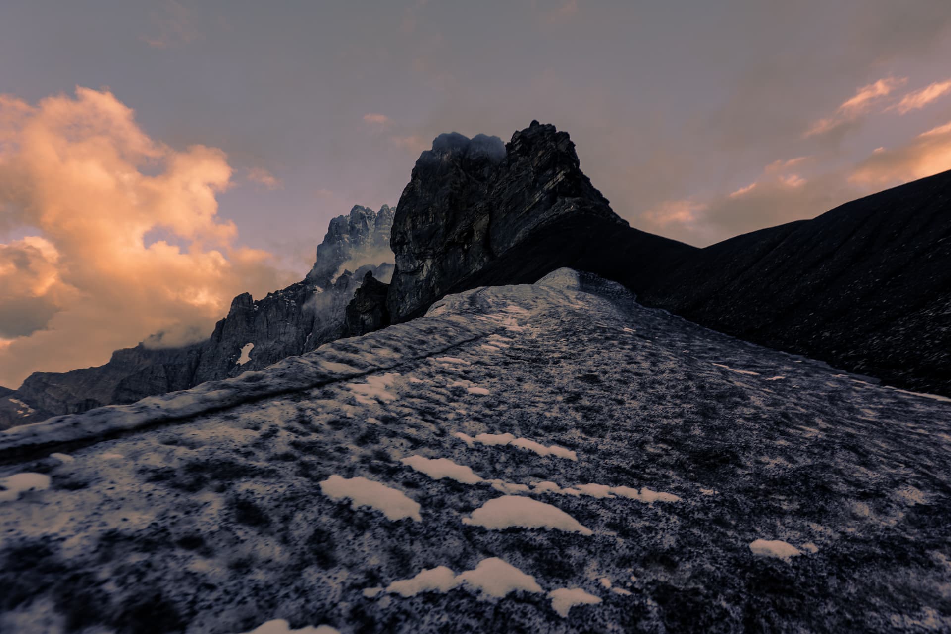 Letztes Licht auf einem Schneefeld unter dem Felsturm der Dents du Midi
