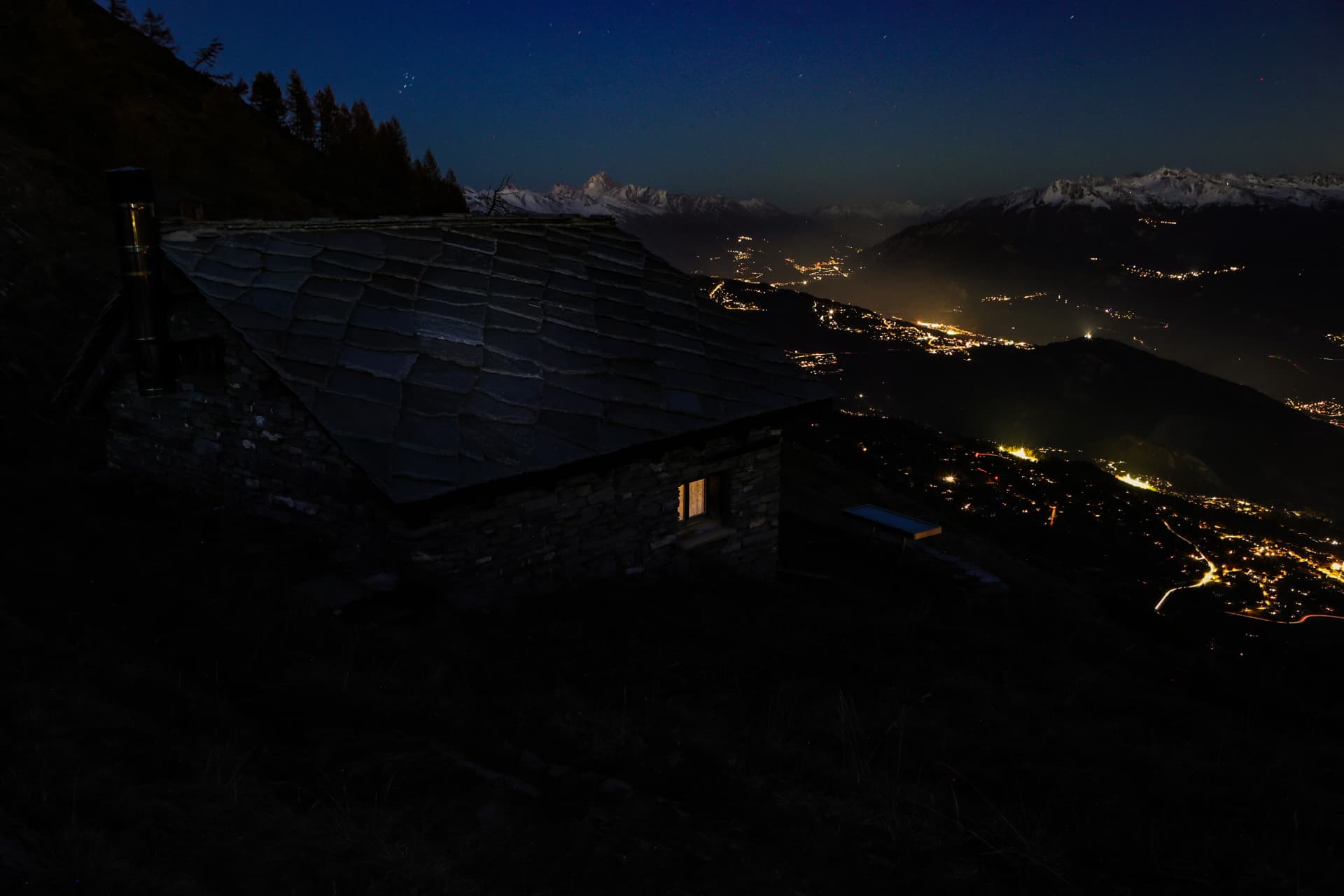 Cabane du Prabé bei Nacht, Licht im Fenster, unten die Lichter des Rhonetals