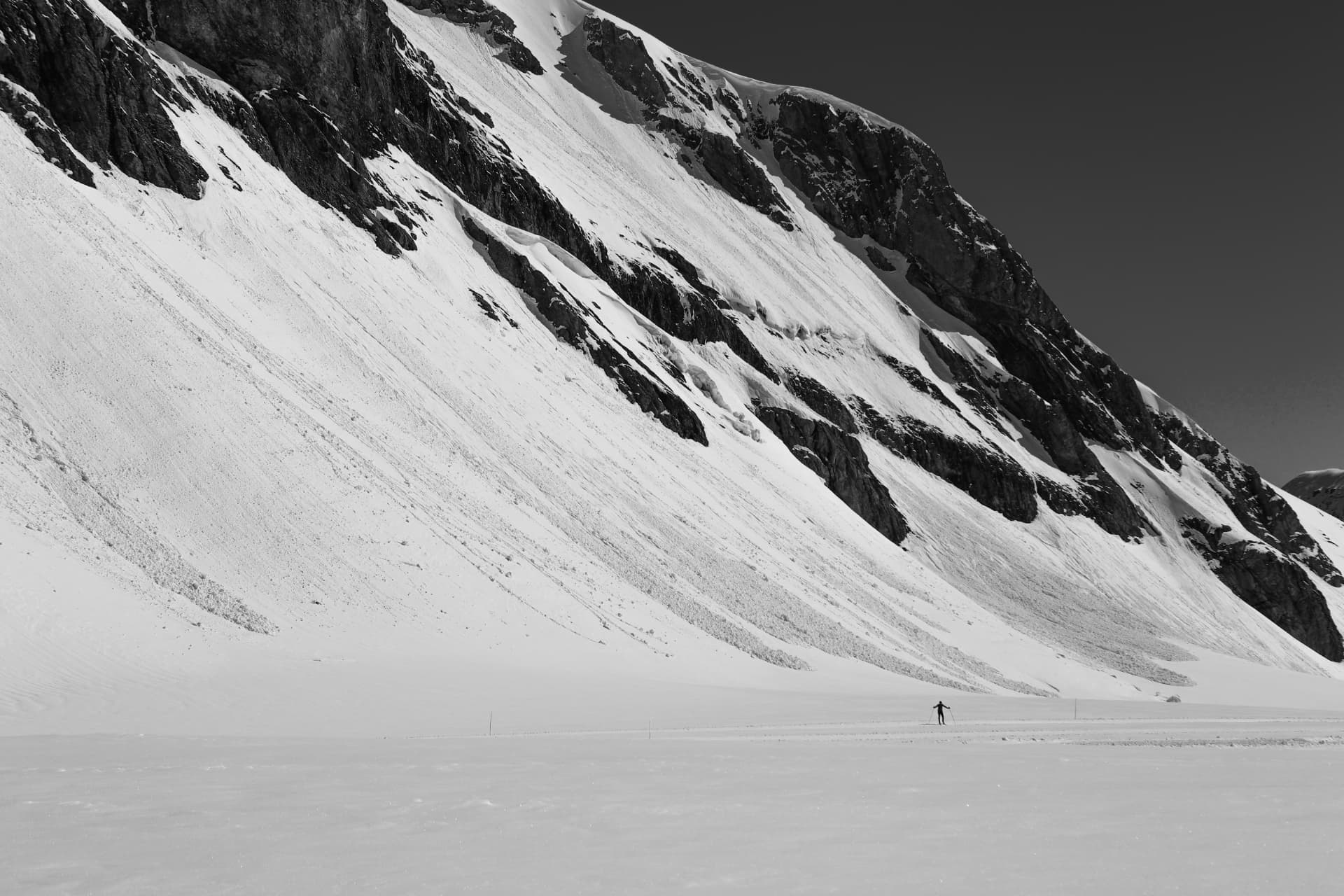 Skifahrer unter einer mächtigen Schneewand am Gletscher