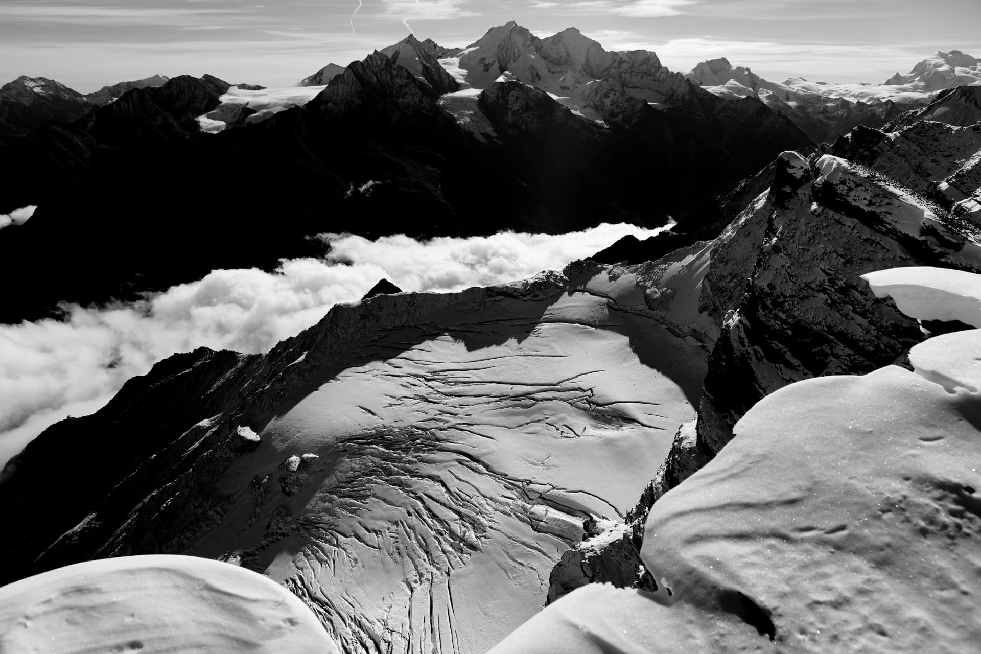 Schwarz-Weiß-Panorama von Gletscher und fernen Gipfeln über Schneewächten