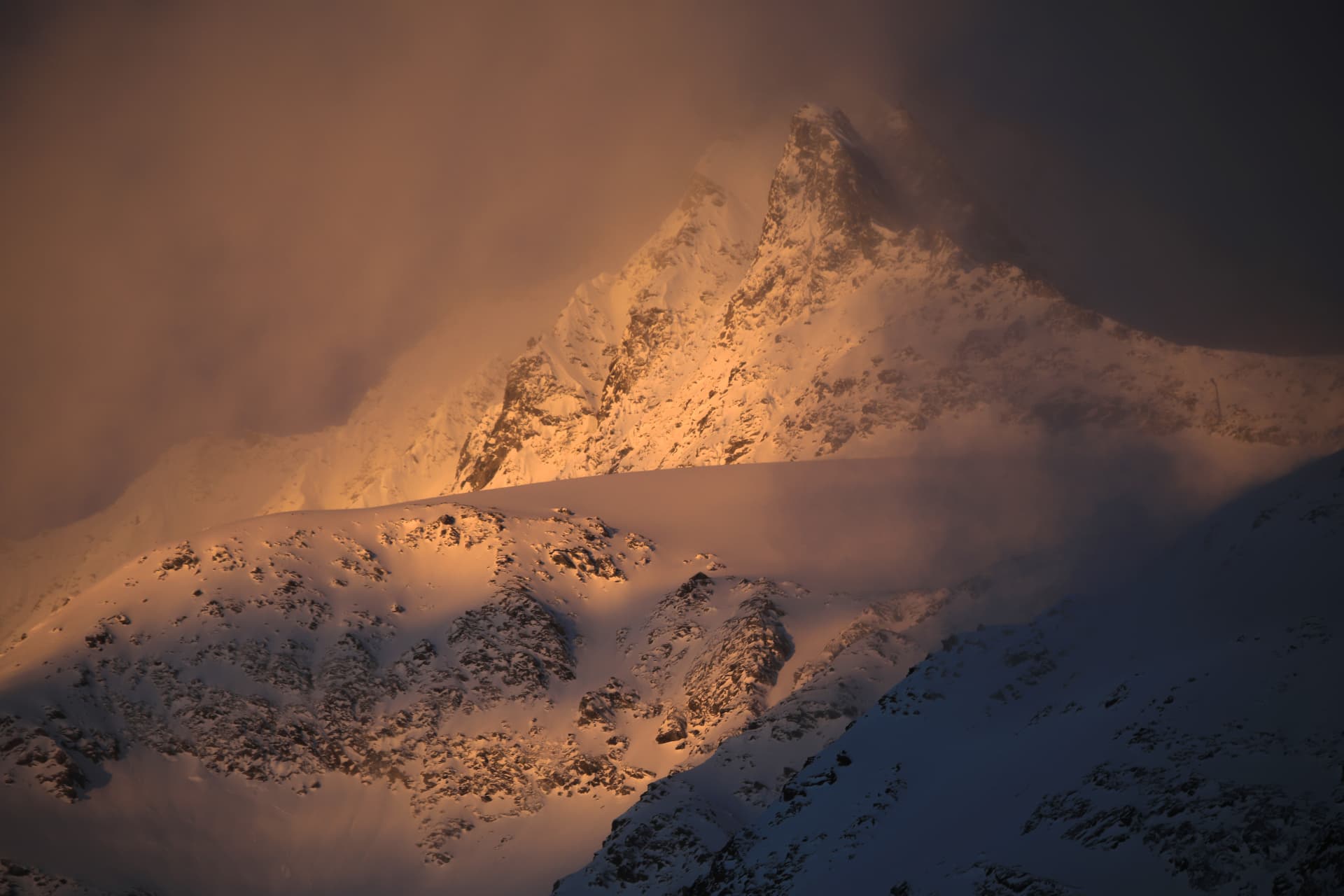 Gipfel im goldenen Nebel beim Sonnenaufgang über dem Feegletscher
