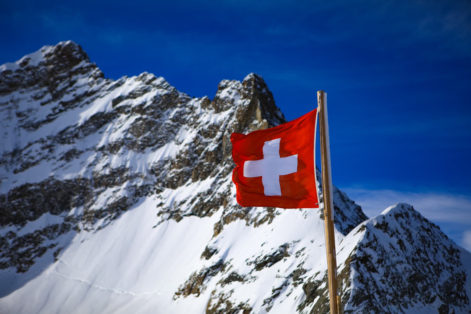 Schweizer Flagge vor verschneiten Felsen am Jungfraujoch