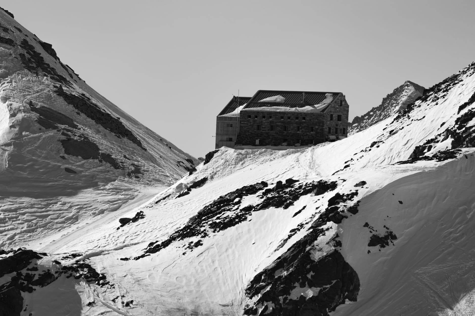 Steinhütte im Schnee über Saas-Fee, schwarzweiss
