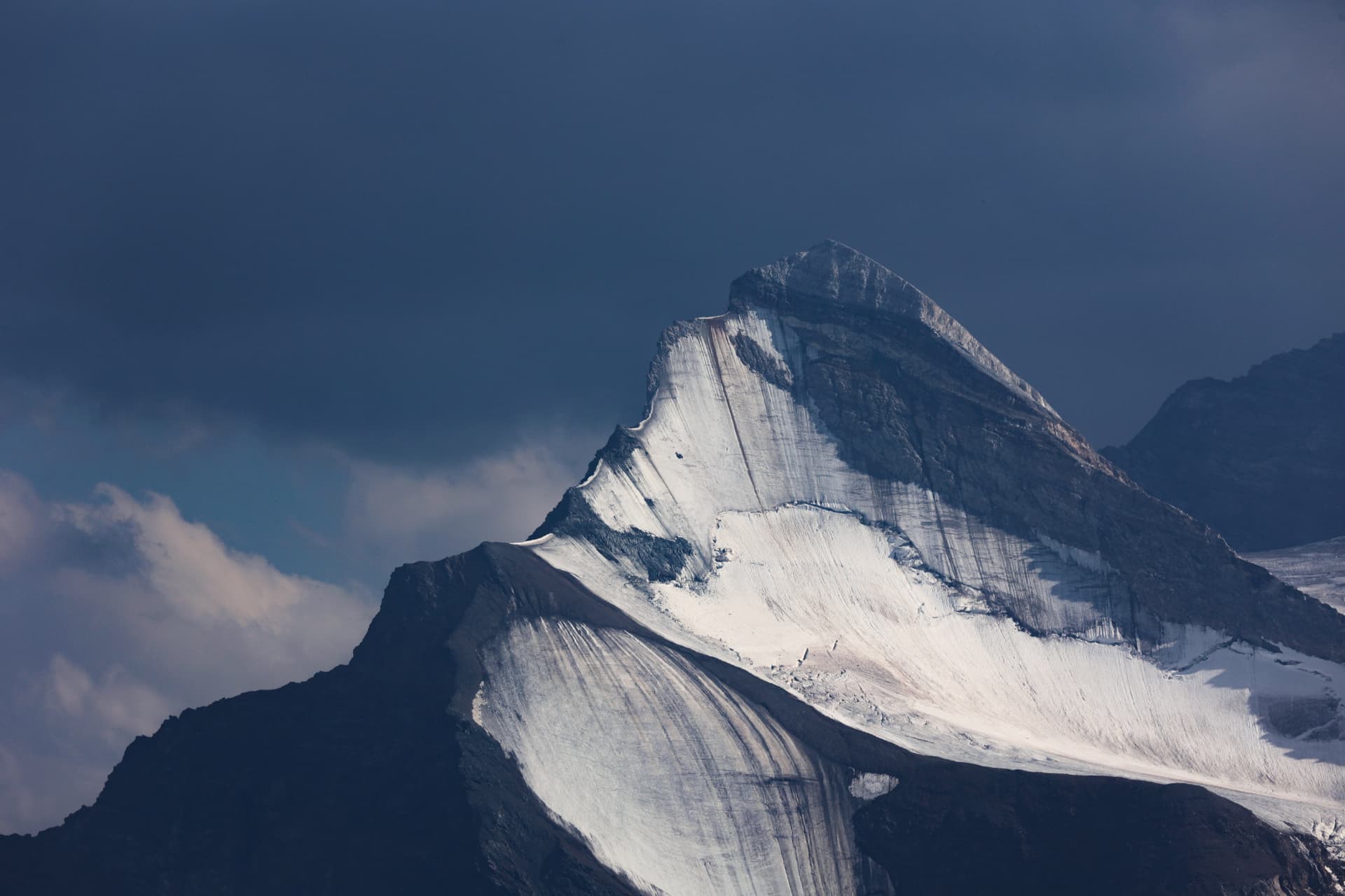Die Schneeflanke des Brunegghorns im harten Licht vor dunklem Himmel