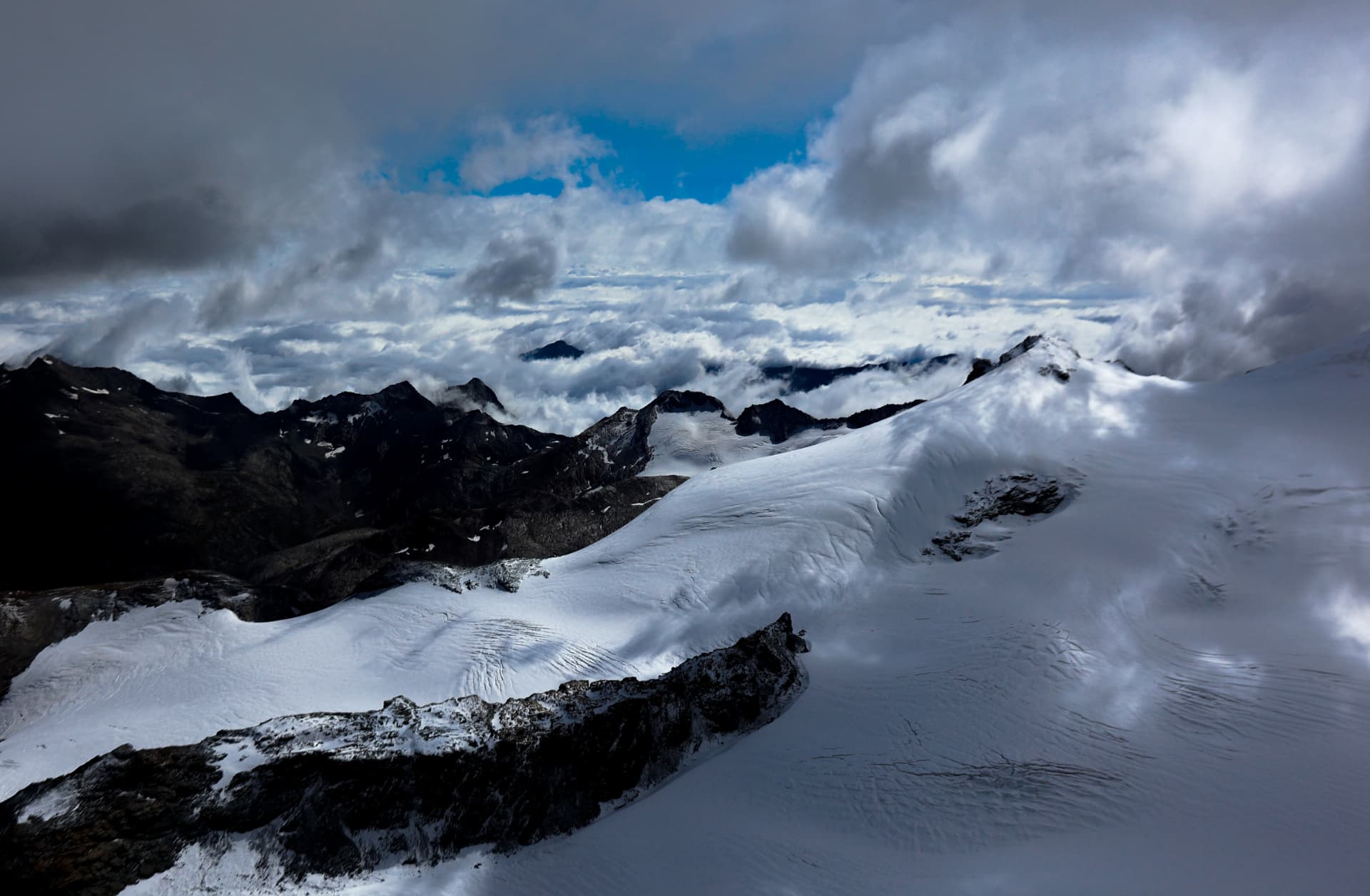 Gletscher und Grate über dem Wolkenmeer, Blick vom Gipfel