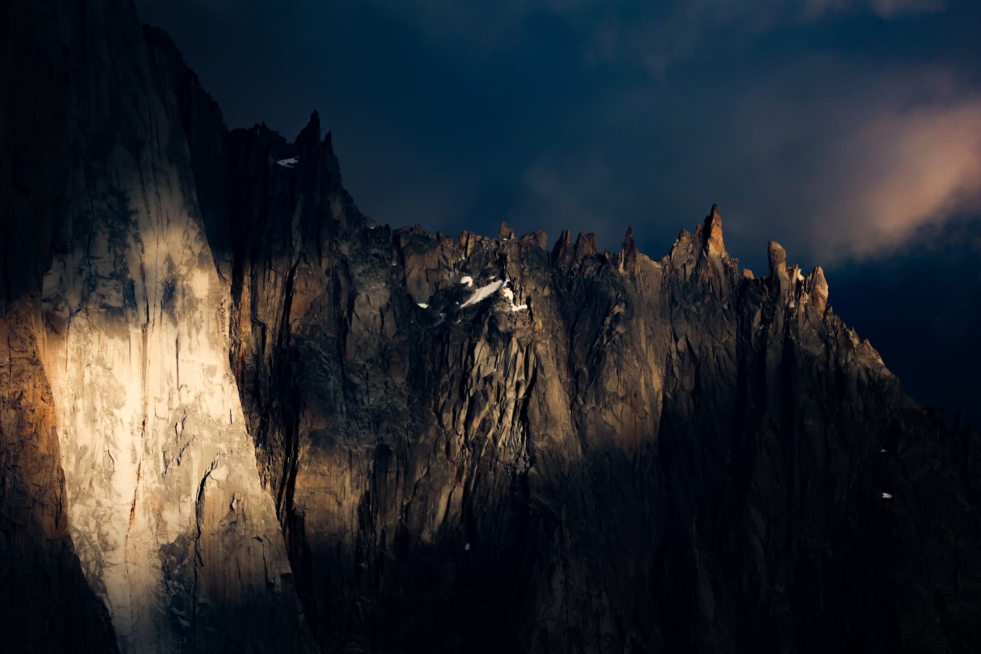 Punktlicht auf einer Granitwand, der übrige Grat im Schatten