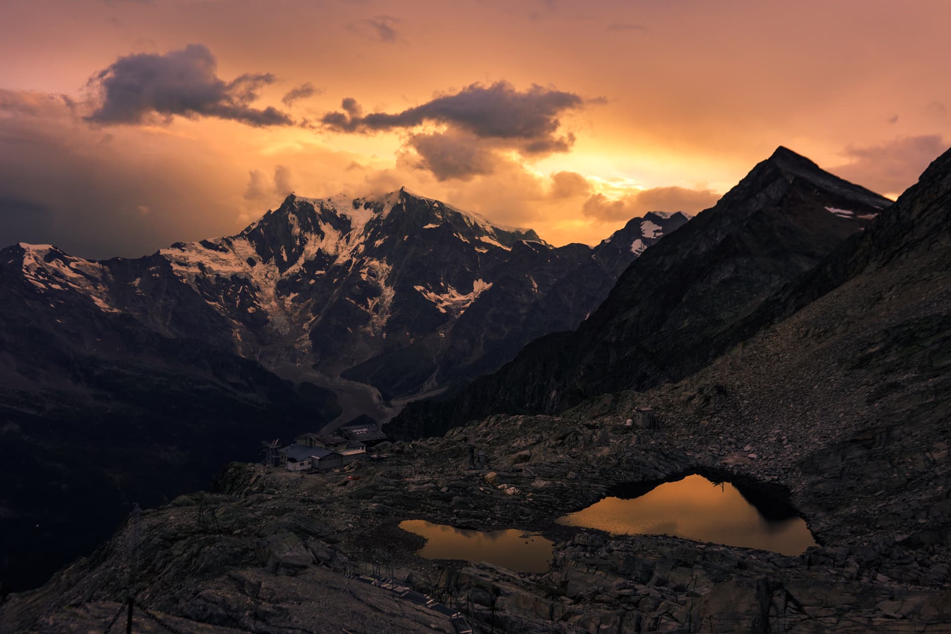 Abendlicht über dem Tal und den verschneiten Gipfeln der Walliser Alpen