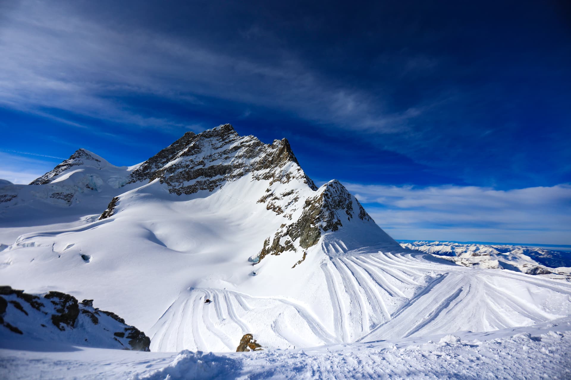 Schneehänge und felsiger Gipfel unter blauem Himmel am Jungfraujoch