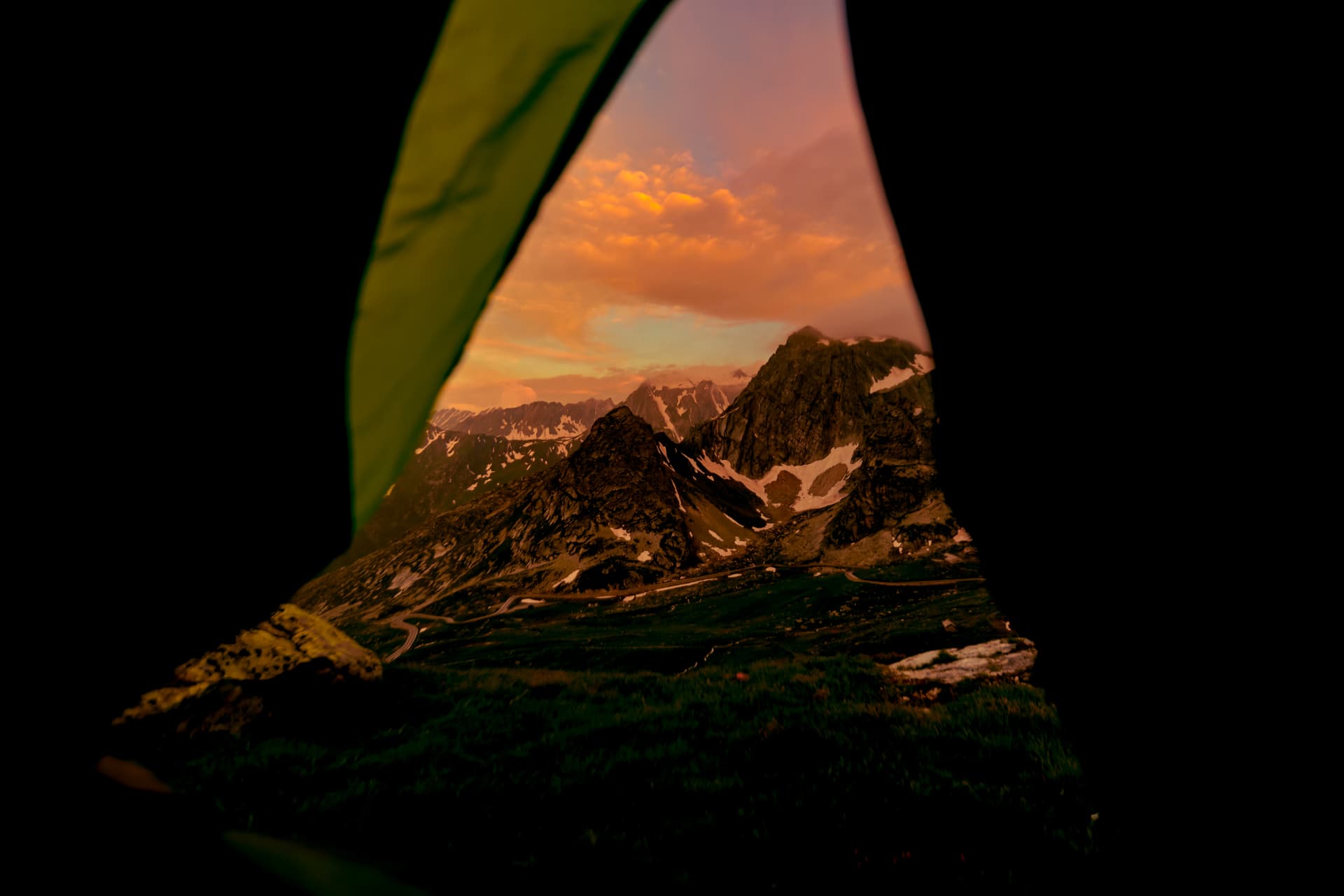 Blick aus dem Zelt auf Berge und orange Wolken über dem Grossen Sankt Bernhard